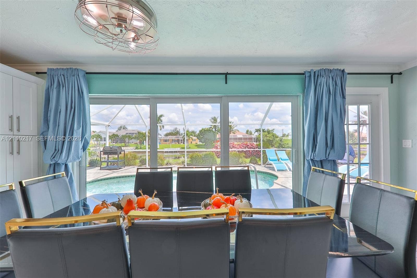 503 SW 17 Street, Cape Coral, FL 33990 Large sliding glass doors with direct access to the exterior, recessed ceiling fan with cage-style fixture, and full-height built-in cabinetry
