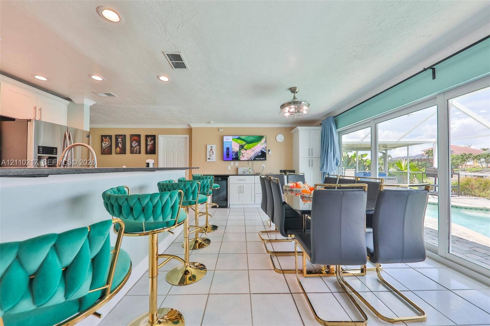503 SW 17 Street, Cape Coral, FL 33990 Kitchen featuring a stone-topped breakfast bar, recessed ceiling lighting, built-in cabinetry, tile flooring, and sliding glass doors