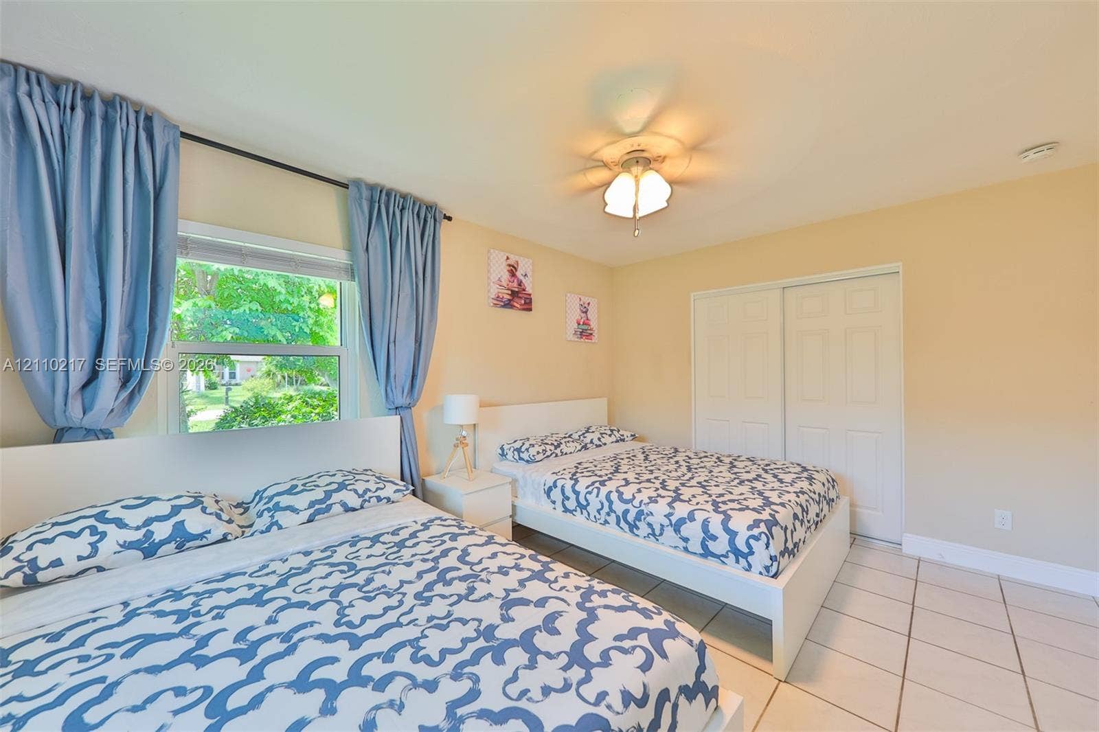 503 SW 17 Street, Cape Coral, FL 33990 Room featuring neutral wall paint, tile flooring, sliding closet doors, and a ceiling fan with light fixture