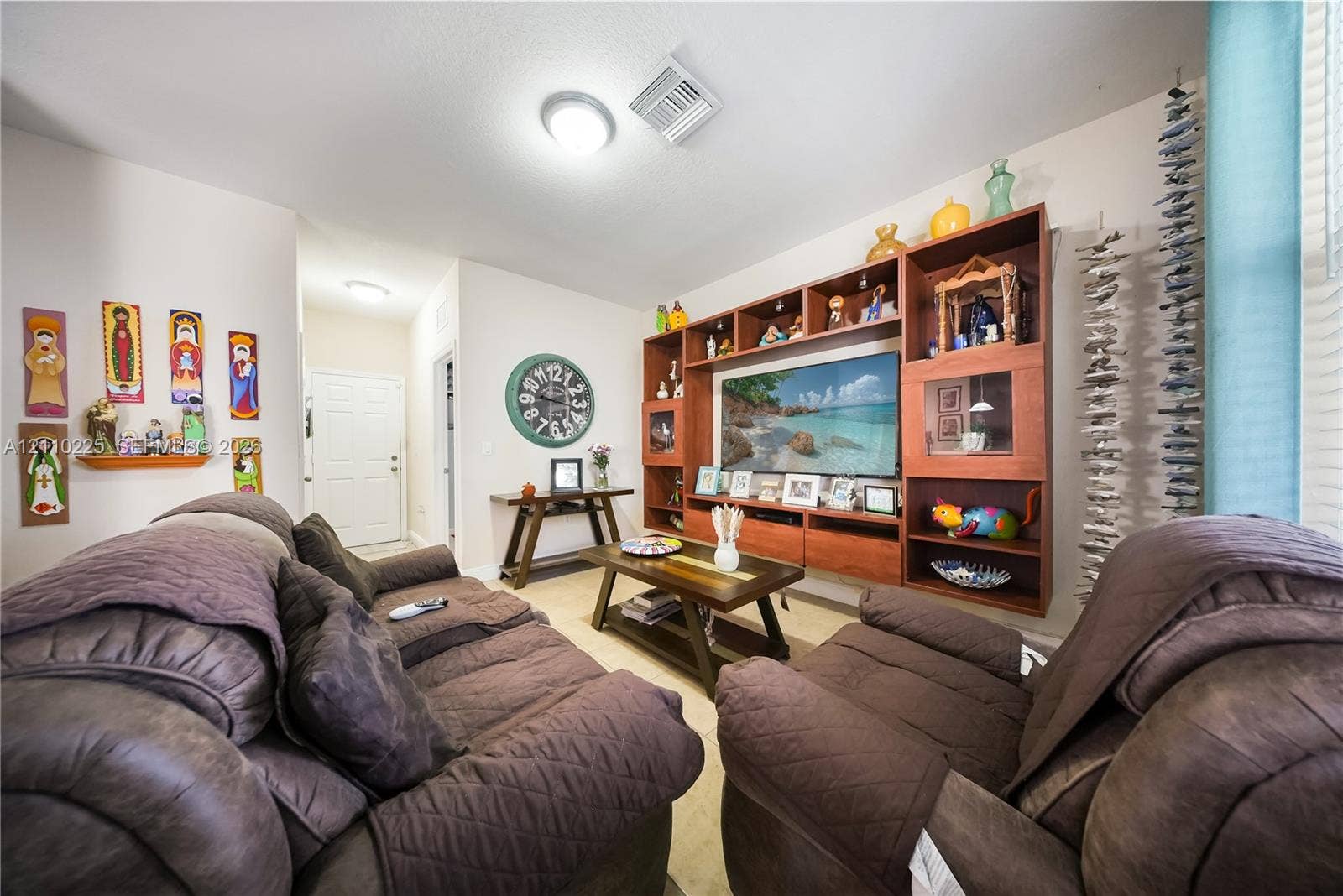 Large-scale wooden wall-to-wall built-in shelving unit featuring integrated media storage and glass display cabinetry