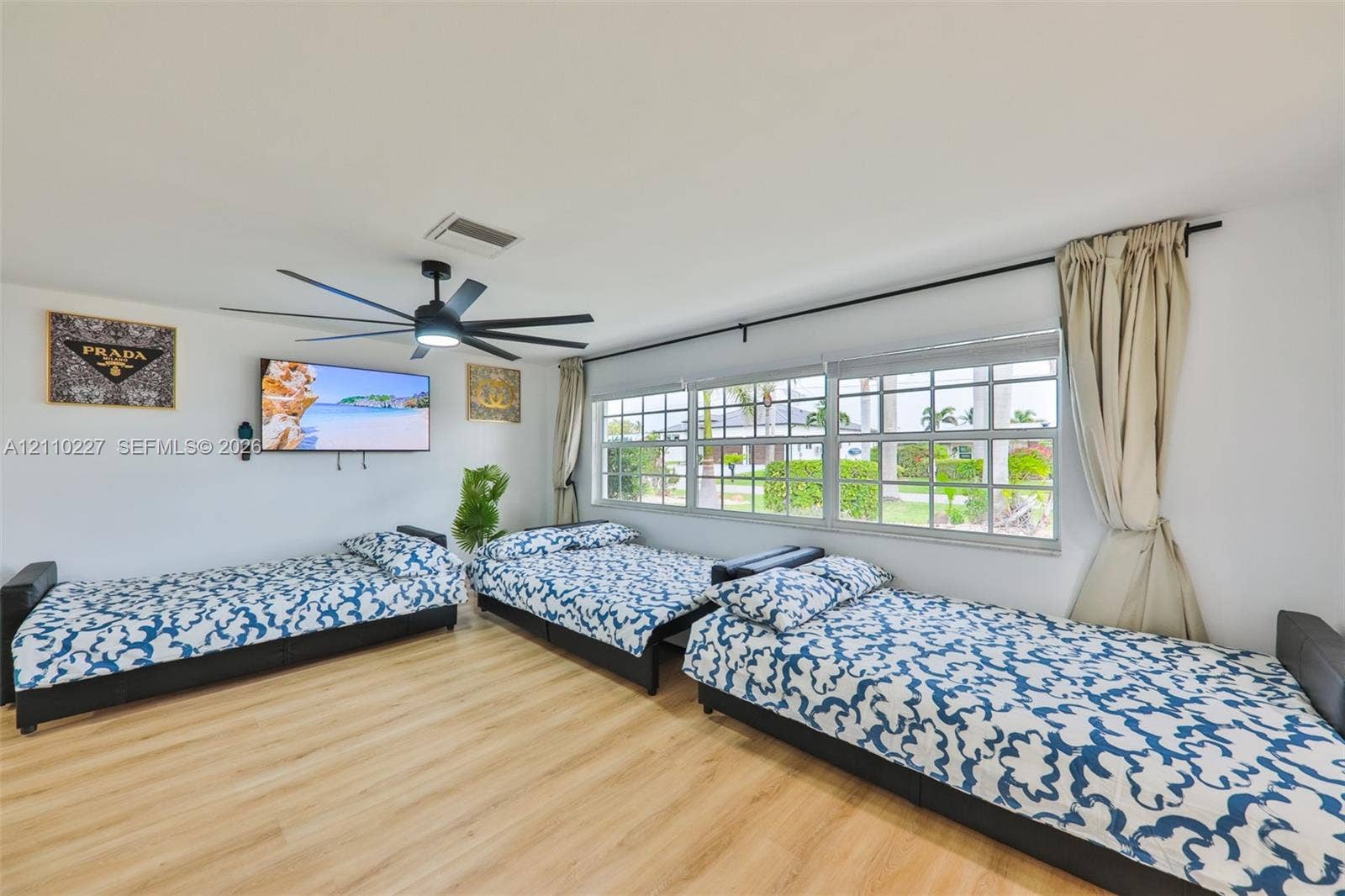 450 Bayshore Drive, Cape Coral, FL 33904 Wood-finish flooring, multi-pane windows, and a large-diameter ceiling fan with integrated lighting