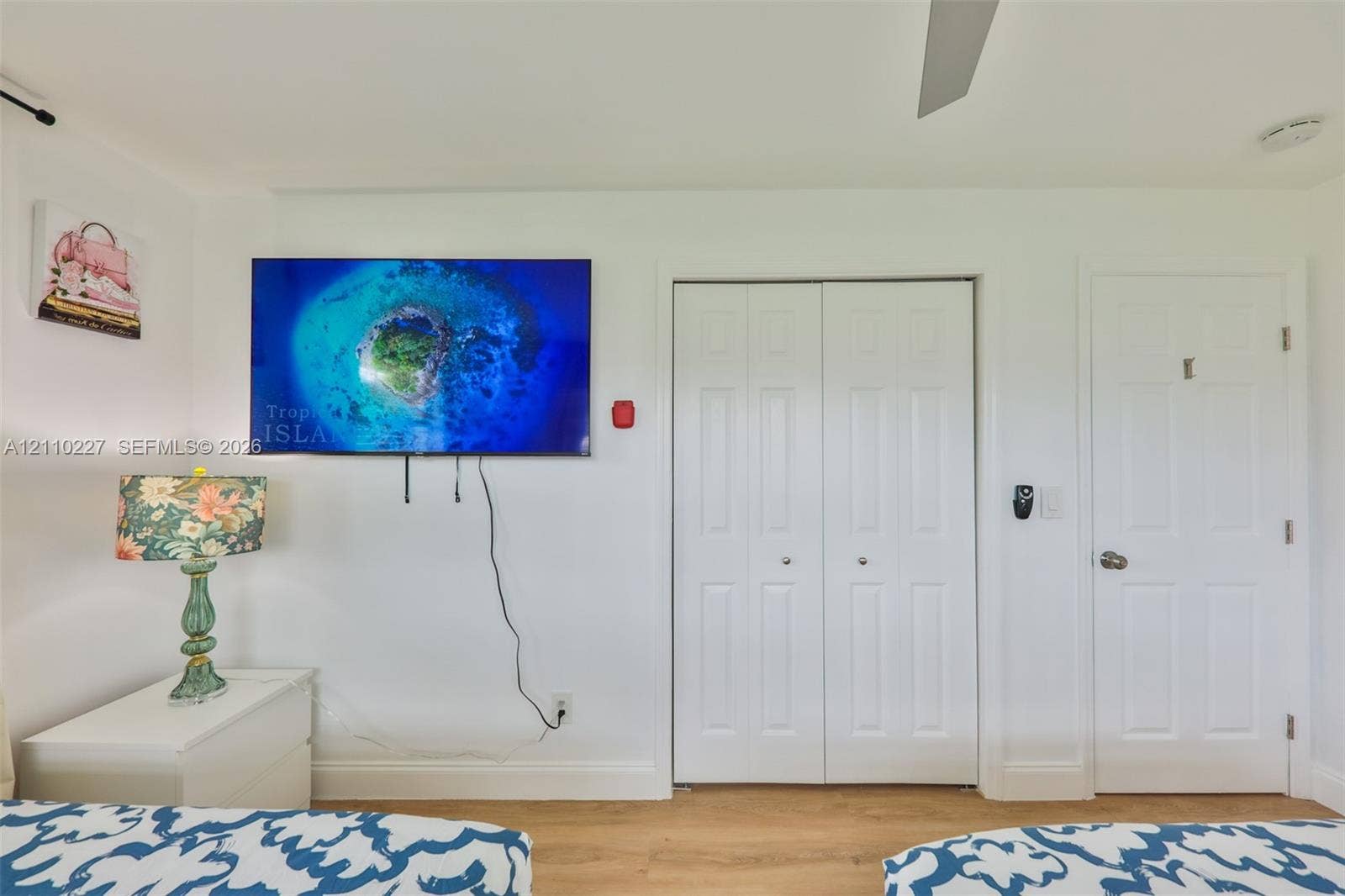 450 Bayshore Drive, Cape Coral, FL 33904 Wood-finish flooring, double-panel closet doors, and interior paneled door featuring brushed-nickel hardware