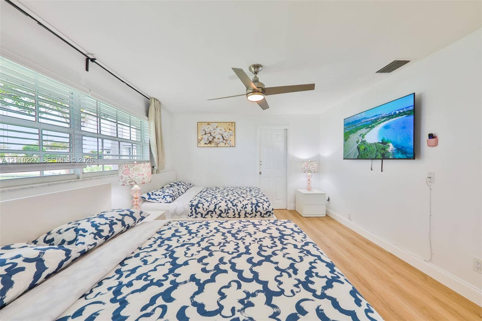 450 Bayshore Drive, Cape Coral, FL 33904 Interior space featuring wood-finish flooring, a multi-pane horizontal window, and a brushed nickel ceiling fan with integrated lighting