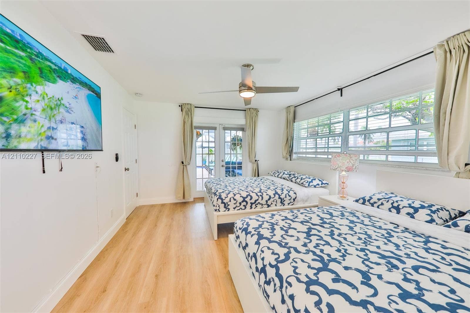 450 Bayshore Drive, Cape Coral, FL 33904 Bright room featuring wood-finish flooring, a contemporary ceiling fan, and multi-pane glass french doors