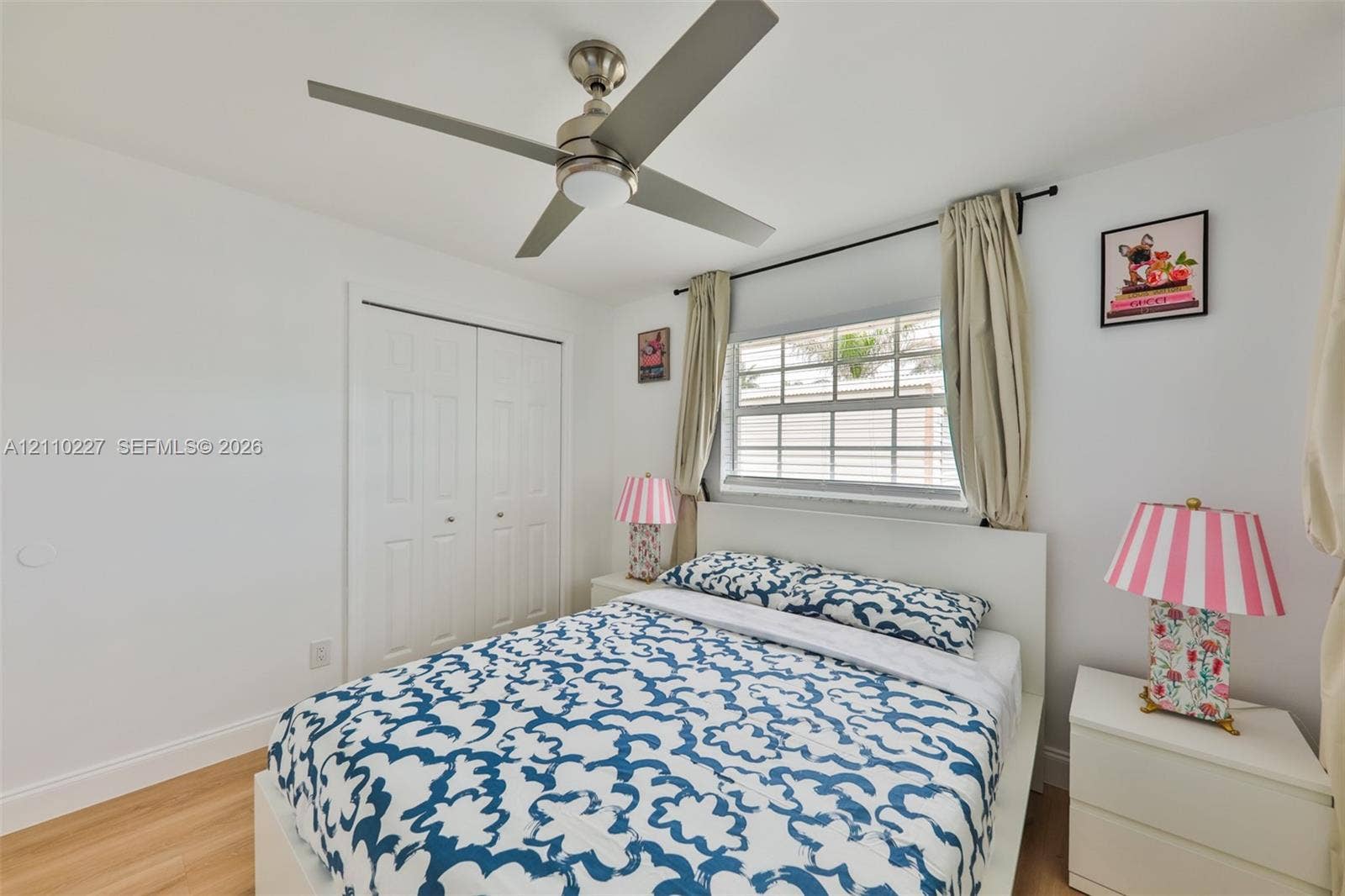 450 Bayshore Drive, Cape Coral, FL 33904 Wood-finish flooring, brushed nickel ceiling fan with integrated lighting, dual-panel closet doors, and multi-pane horizontal window
