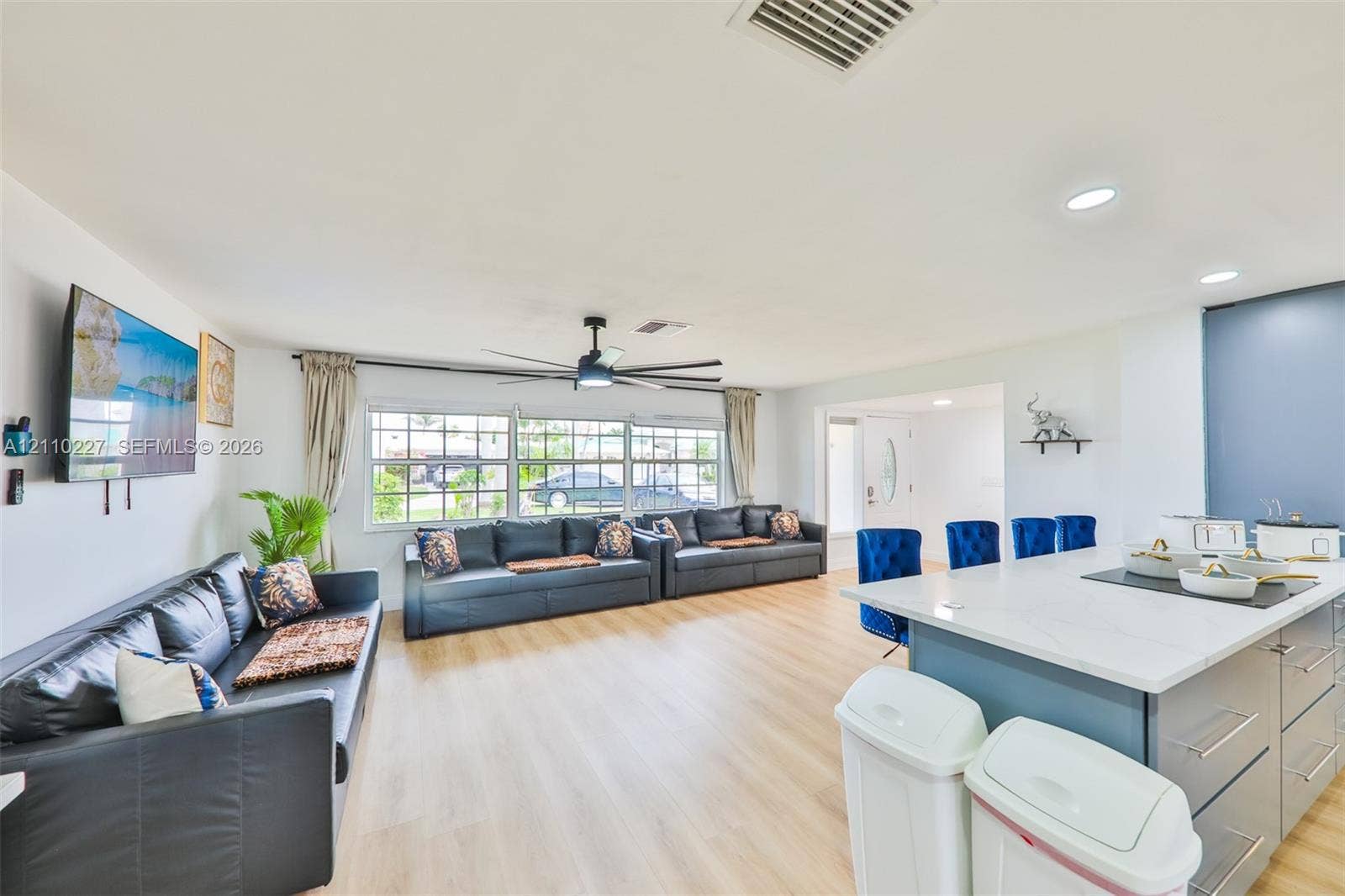 450 Bayshore Drive, Cape Coral, FL 33904 Open-concept interior featuring light wood-finish flooring, recessed lighting, a ceiling fan, and a center island with a stone-surface countertop and cabinetry