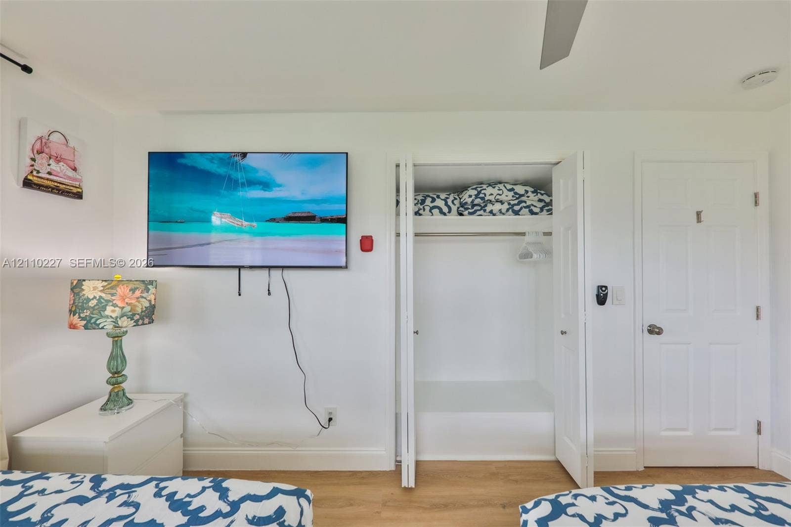 450 Bayshore Drive, Cape Coral, FL 33904 Wood-finish flooring, white four-panel interior door, and bi-fold closet doors with integrated shelving