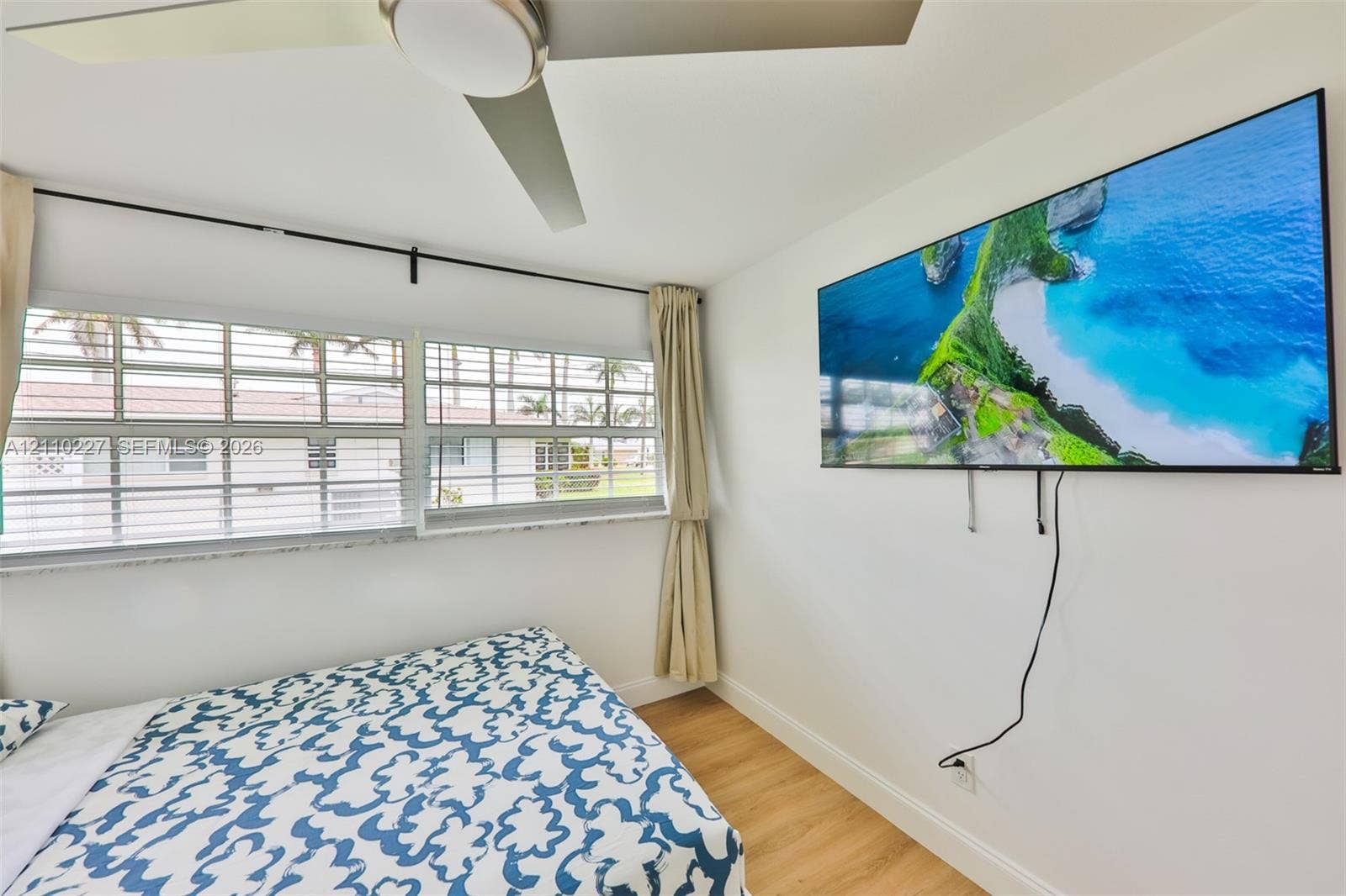 450 Bayshore Drive, Cape Coral, FL 33904 Wood-finish flooring, multi-pane horizontal windows with sills, and a central ceiling fan with integrated lighting