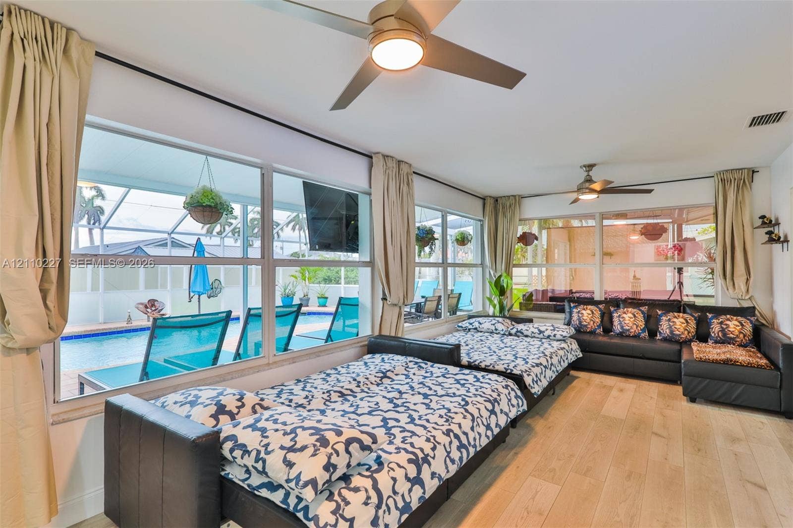 450 Bayshore Drive, Cape Coral, FL 33904 Floor-to-ceiling windows, wood-finish flooring, and dual ceiling fans