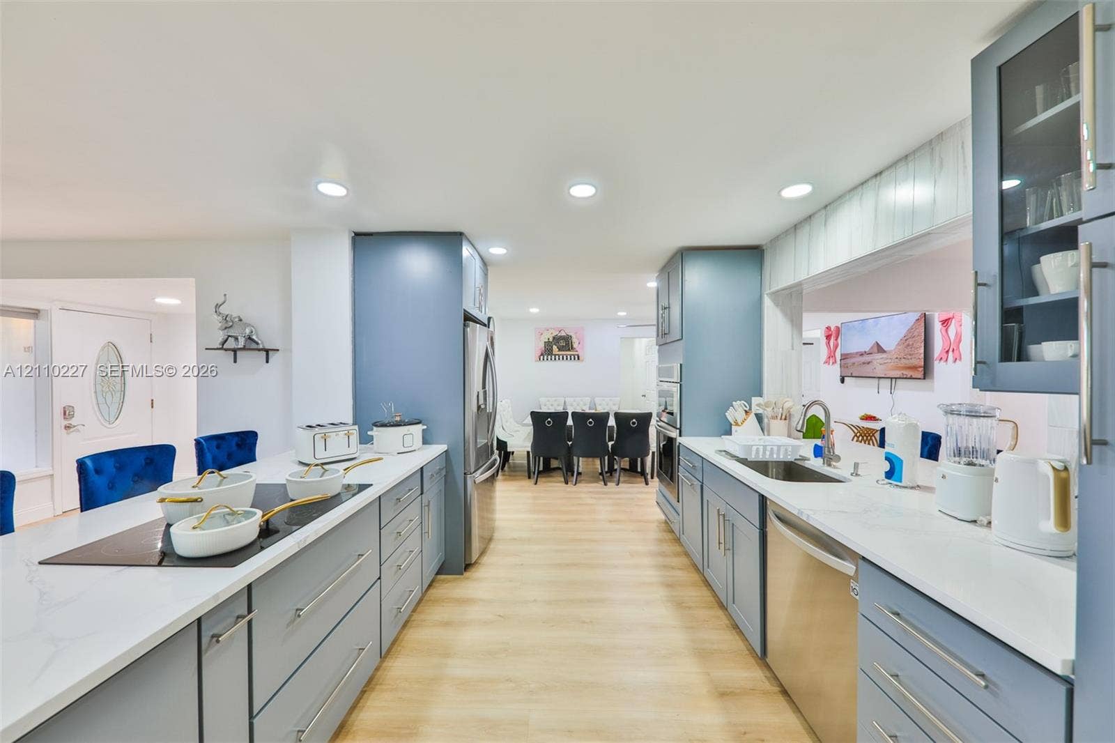 450 Bayshore Drive, Cape Coral, FL 33904 Kitchen featuring light blue cabinetry, stone-finish countertops, stainless steel appliances, a built-in cooktop, and wood-finish flooring