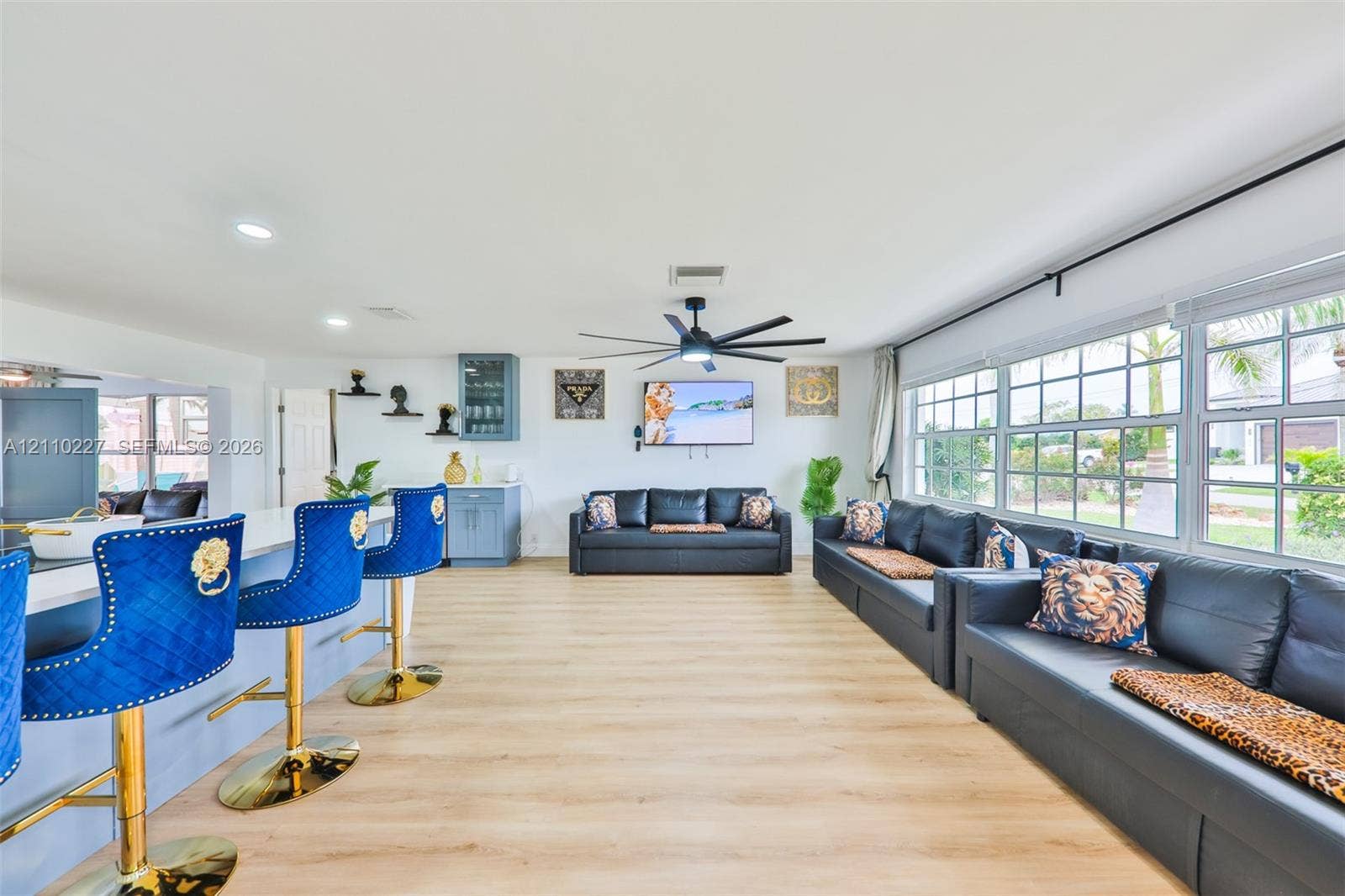 450 Bayshore Drive, Cape Coral, FL 33904 Open-concept interior featuring light-toned wood-finish flooring, recessed lighting, multi-blade ceiling fan, and large windows with grid muntins