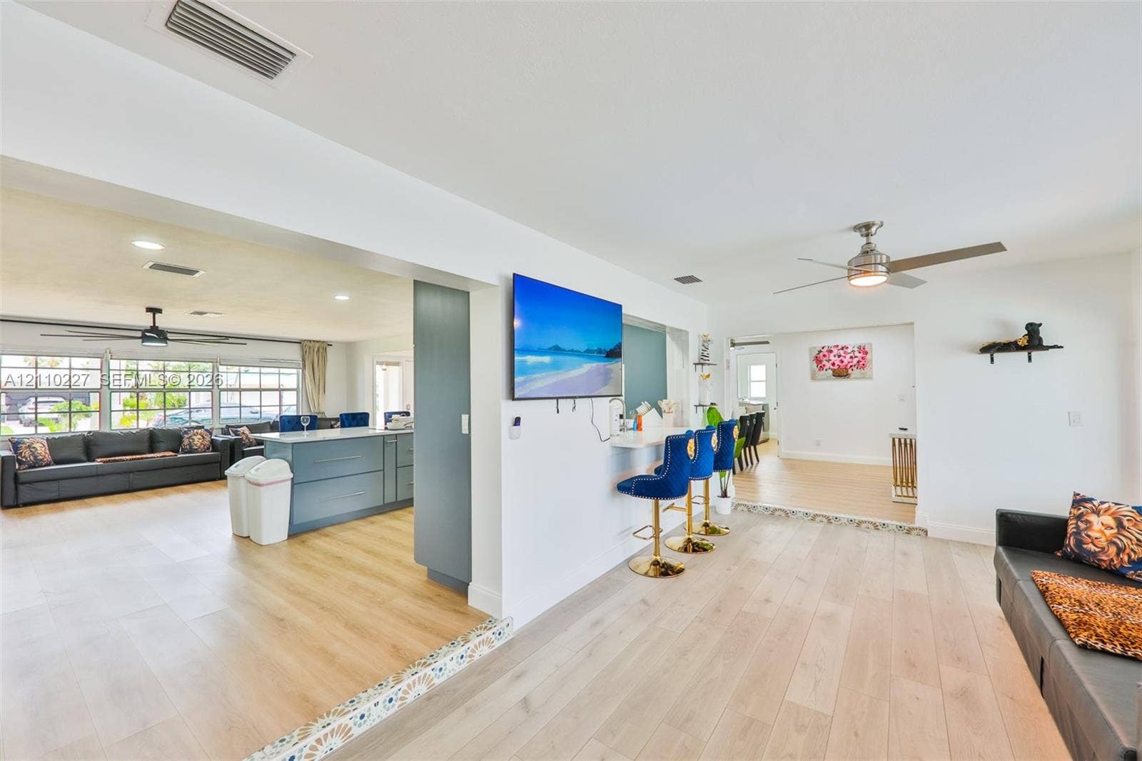 450 Bayshore Drive, Cape Coral, FL 33904 Open-concept interior featuring light wood-finish flooring, recessed lighting, ceiling fans, and a built-in counter