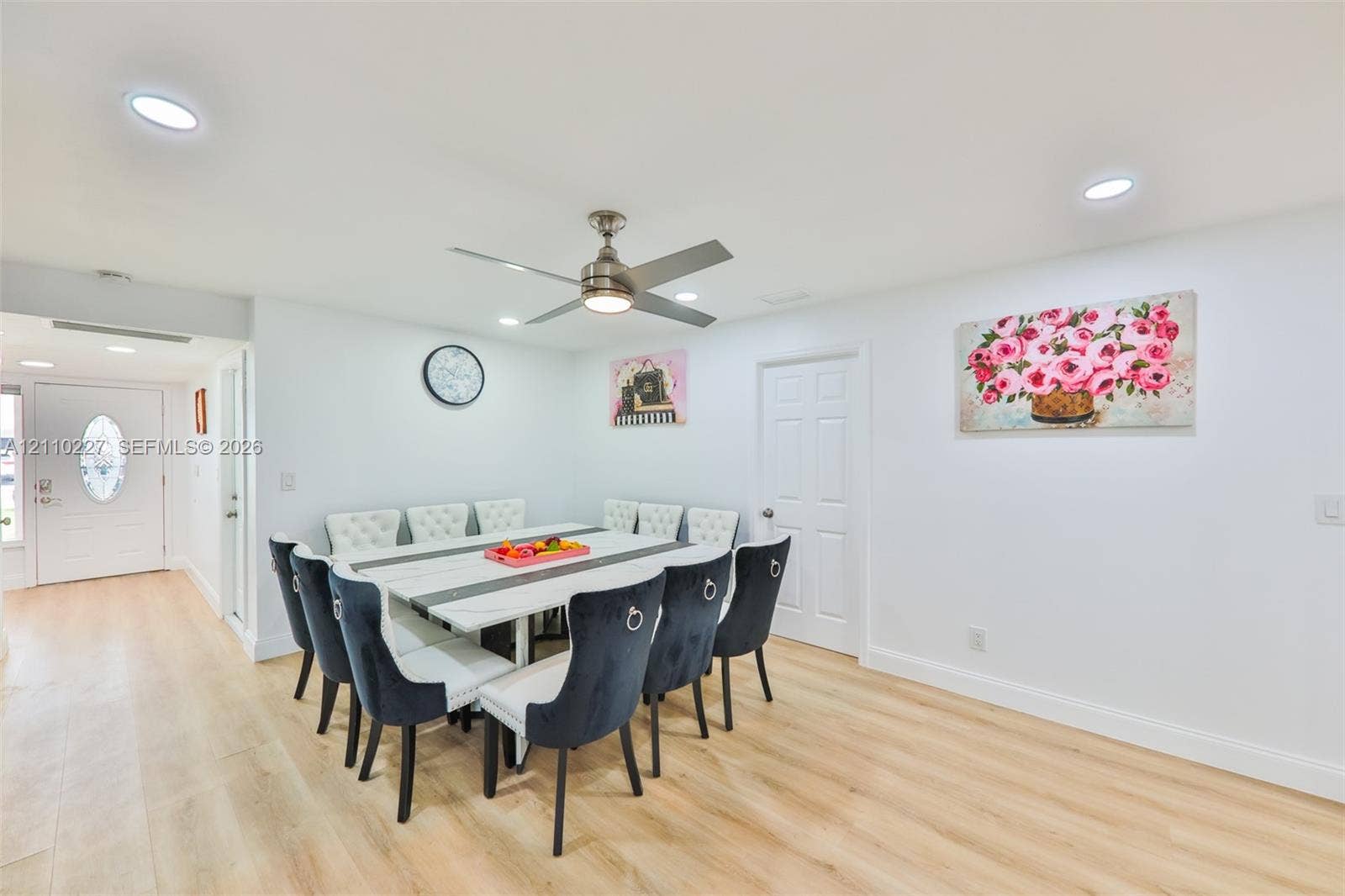 450 Bayshore Drive, Cape Coral, FL 33904 Open-concept space featuring light-toned wood-finish flooring, recessed lighting, a modern ceiling fan with integrated light, and a white six-panel interior door