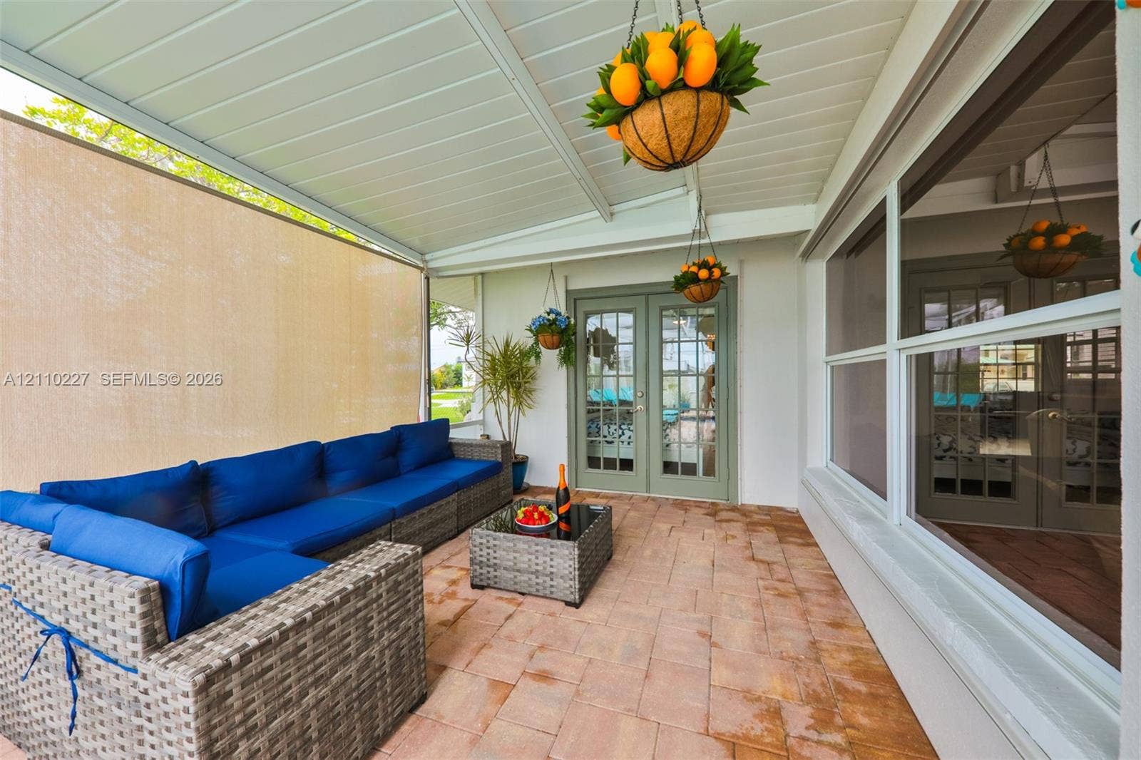 450 Bayshore Drive, Cape Coral, FL 33904 Covered patio featuring a paved floor, beadboard ceiling, privacy screening, and French doors