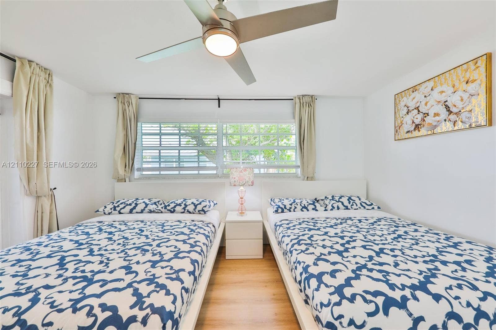 450 Bayshore Drive, Cape Coral, FL 33904 Wood-finish flooring, multi-pane windows with horizontal blinds, and a contemporary ceiling fan with integrated lighting