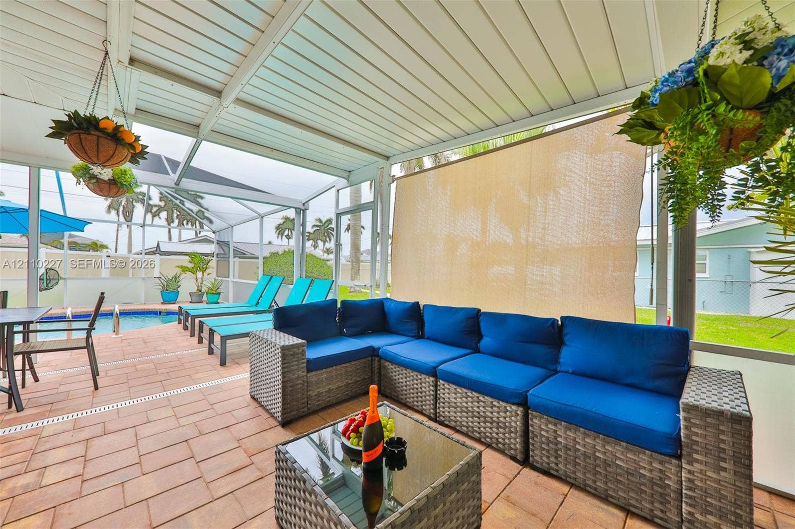 450 Bayshore Drive, Cape Coral, FL 33904 Screened-in lanai featuring paver flooring, an integrated pool, and a white aluminum frame