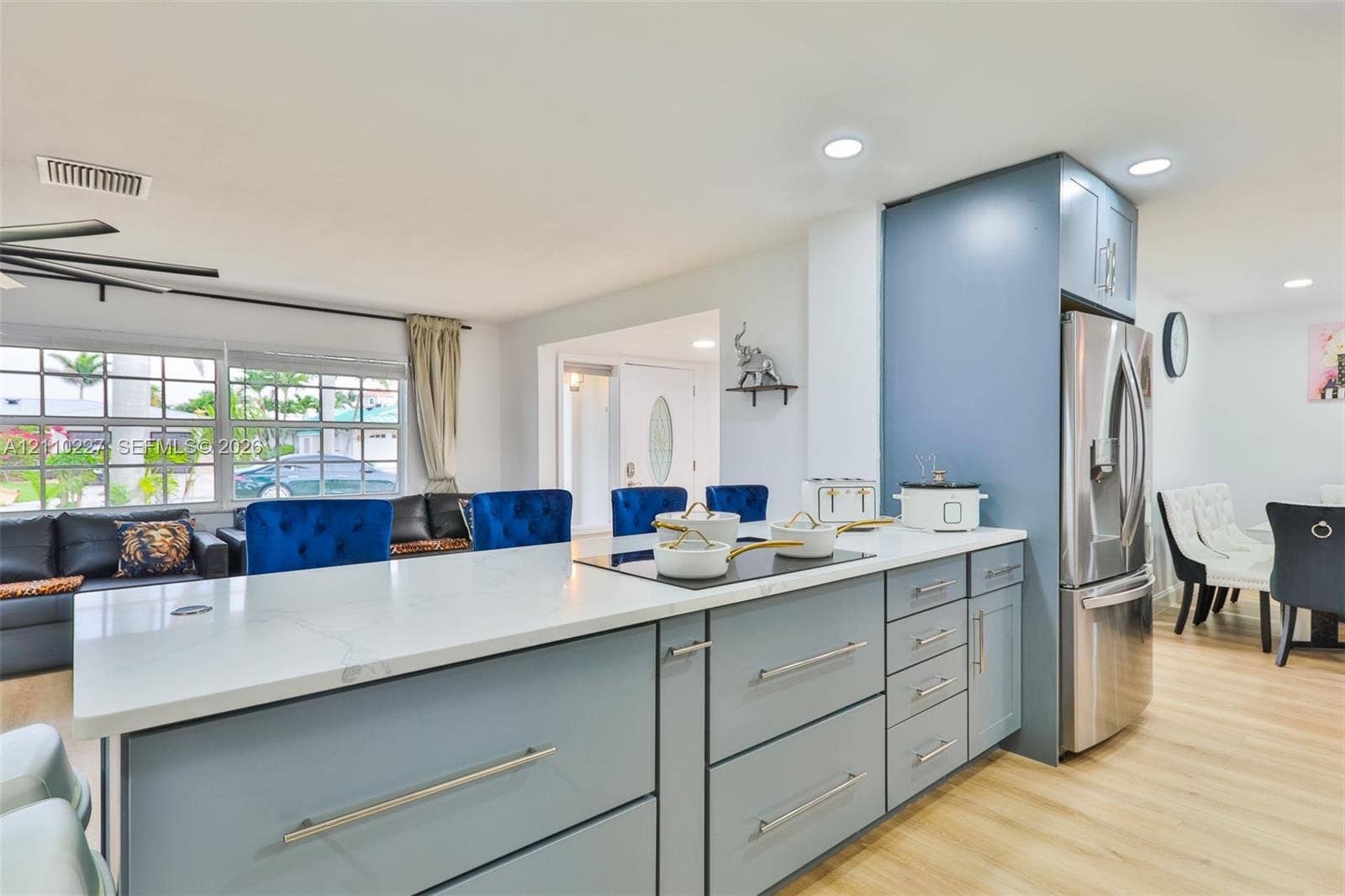 450 Bayshore Drive, Cape Coral, FL 33904 Kitchen featuring a quartz countertop, blue cabinetry with brushed metal pulls, stainless steel refrigerator, recessed lighting, and wood-finish flooring