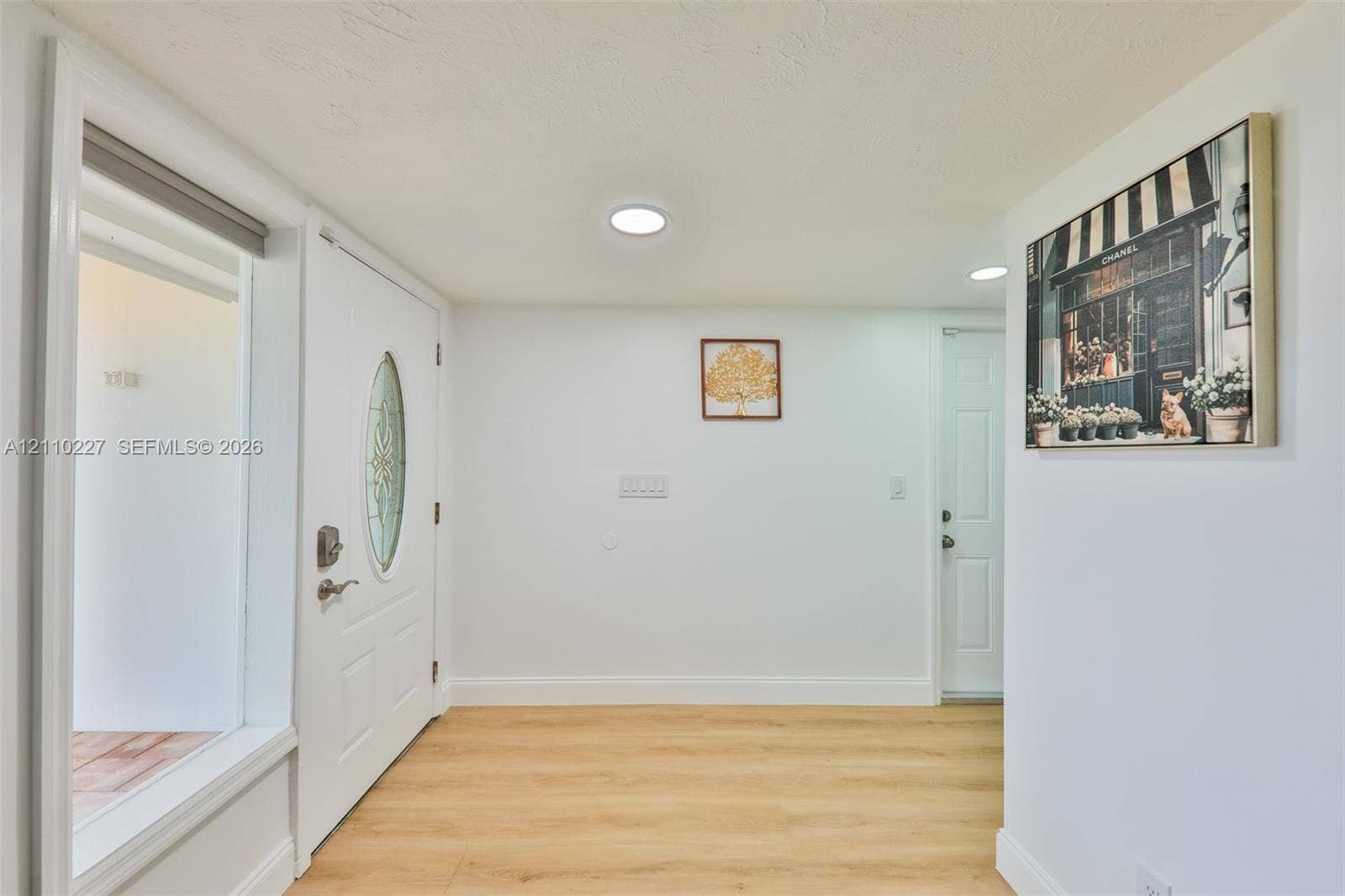 450 Bayshore Drive, Cape Coral, FL 33904 Entryway featuring light wood-finish flooring, recessed lighting, and a white six-panel door with an oval decorative glass insert