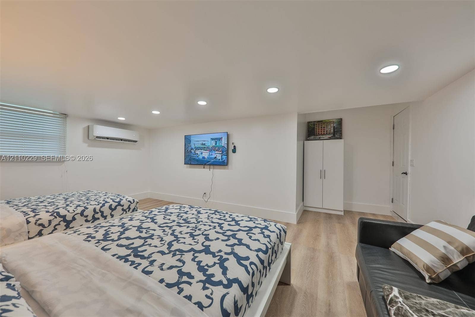 Interior space featuring wood-finish flooring, recessed lighting, and a wall-mounted ductless climate control unit