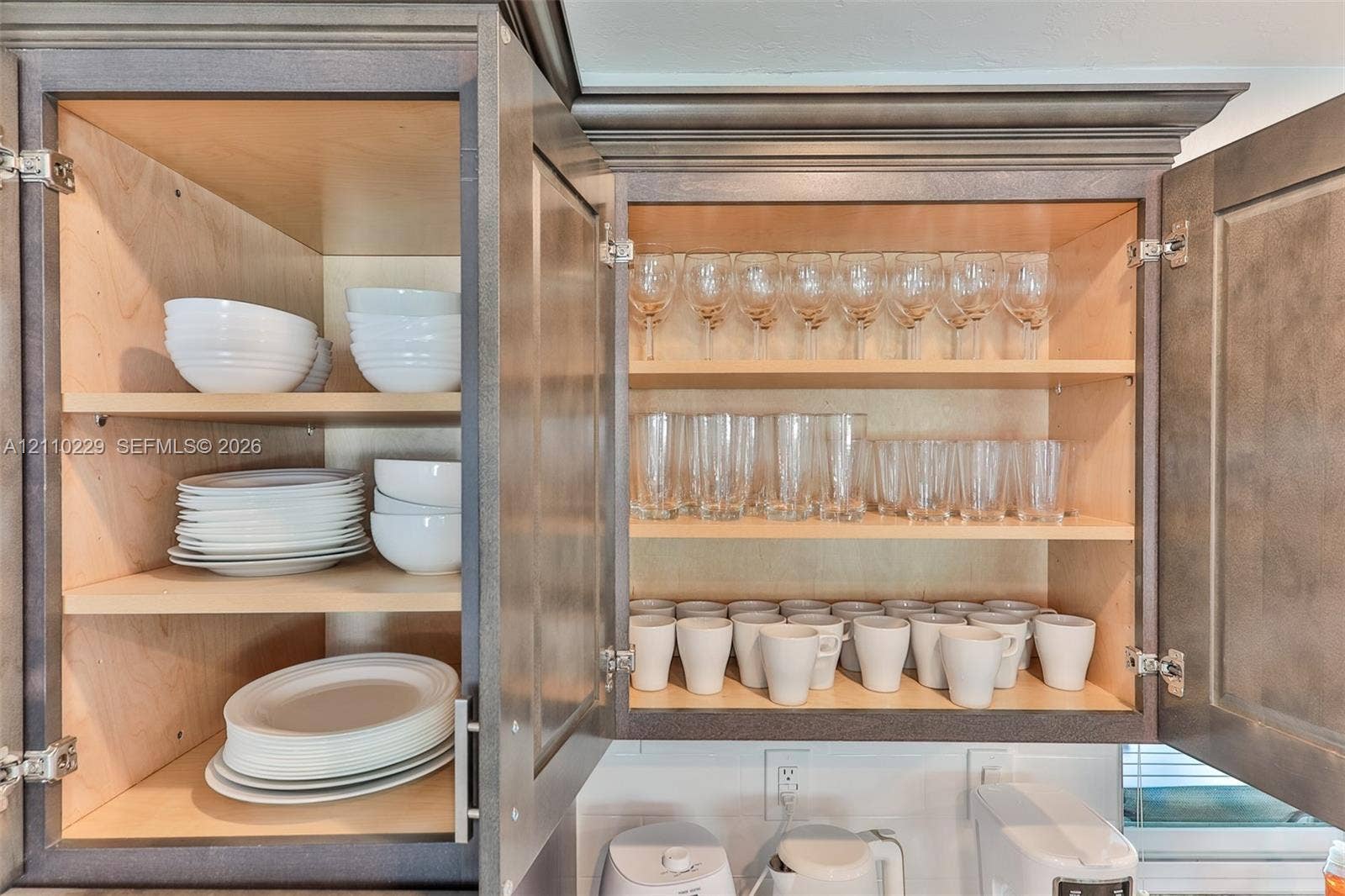 Custom cabinetry featuring flat-panel doors, crown molding, and adjustable shelving