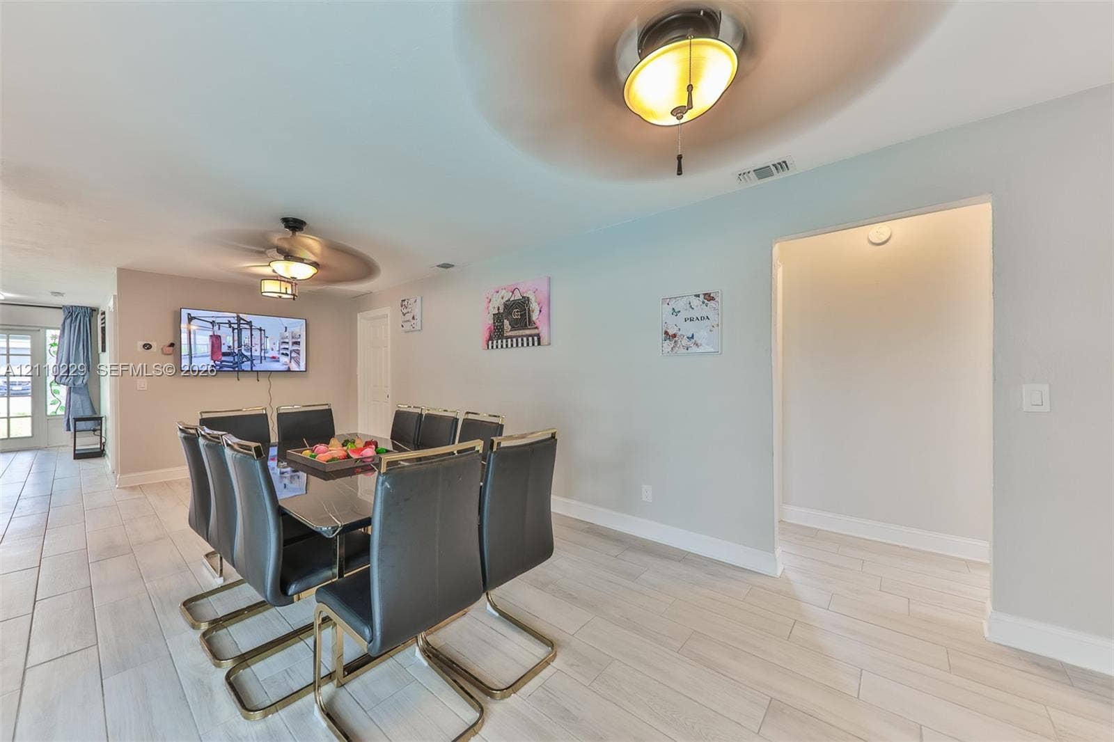 Neutral interior featuring wood-finish tile flooring, a semi-flush mount ceiling fixture, and a ceiling fan with integrated lighting