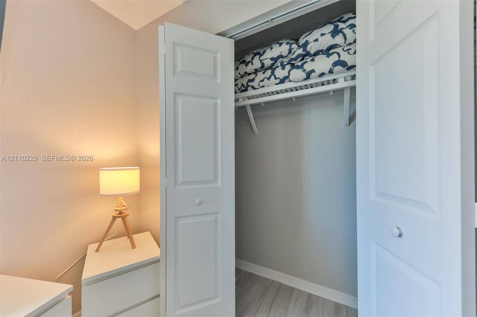 Closet featuring white paneled bifold doors and integrated upper shelving