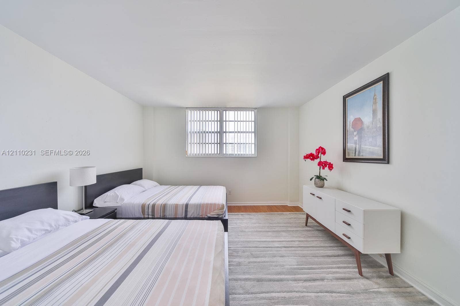 19370 Collins Avenue, #622, Sunny Isles Beach, FL 33160 Spacious room featuring neutral paint, wood-finish flooring, and a large window with vertical blinds