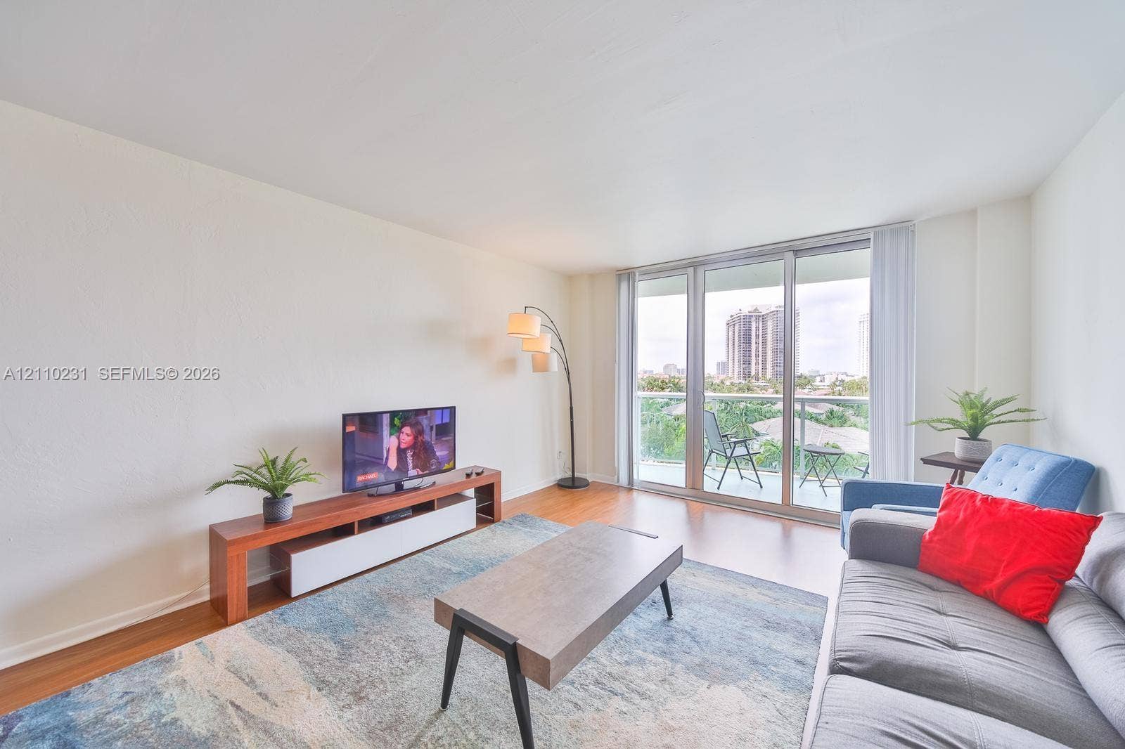 19370 Collins Avenue, #622, Sunny Isles Beach, FL 33160 Living area featuring wood-finish flooring, floor-to-ceiling glass sliding doors, and a private balcony