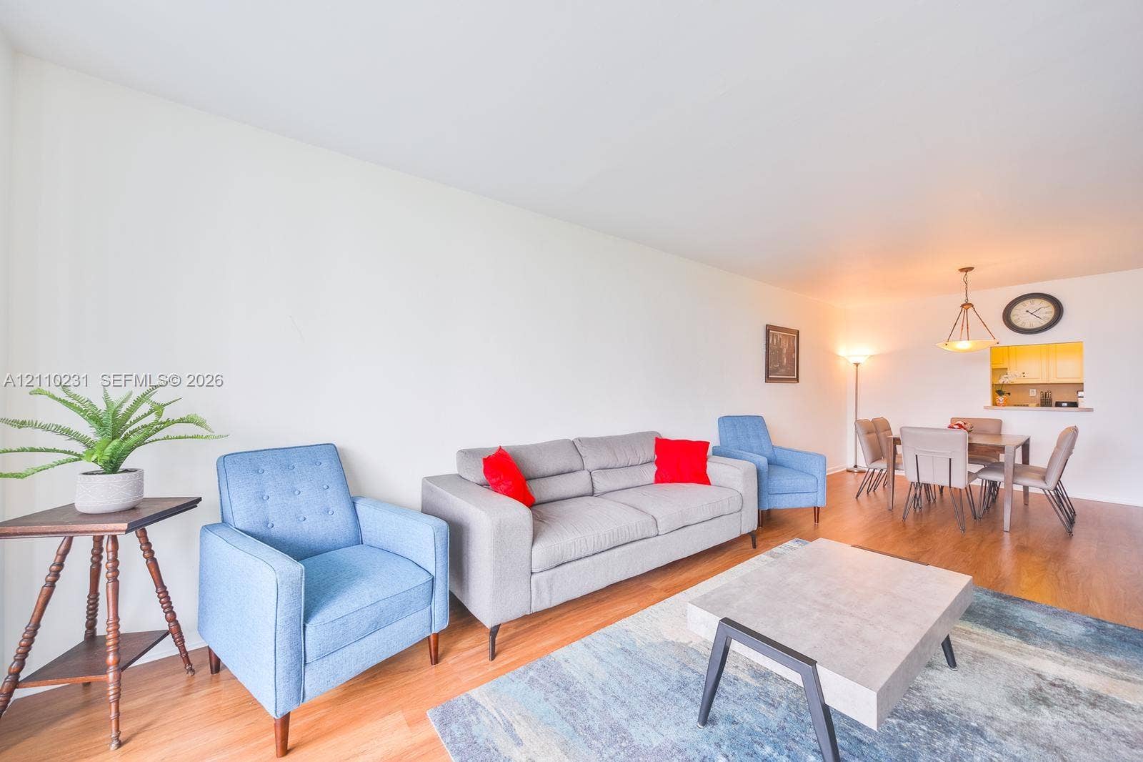 19370 Collins Avenue, #622, Sunny Isles Beach, FL 33160 Open-concept interior featuring wood-finish flooring, a kitchen passthrough, and a tiered pendant light fixture