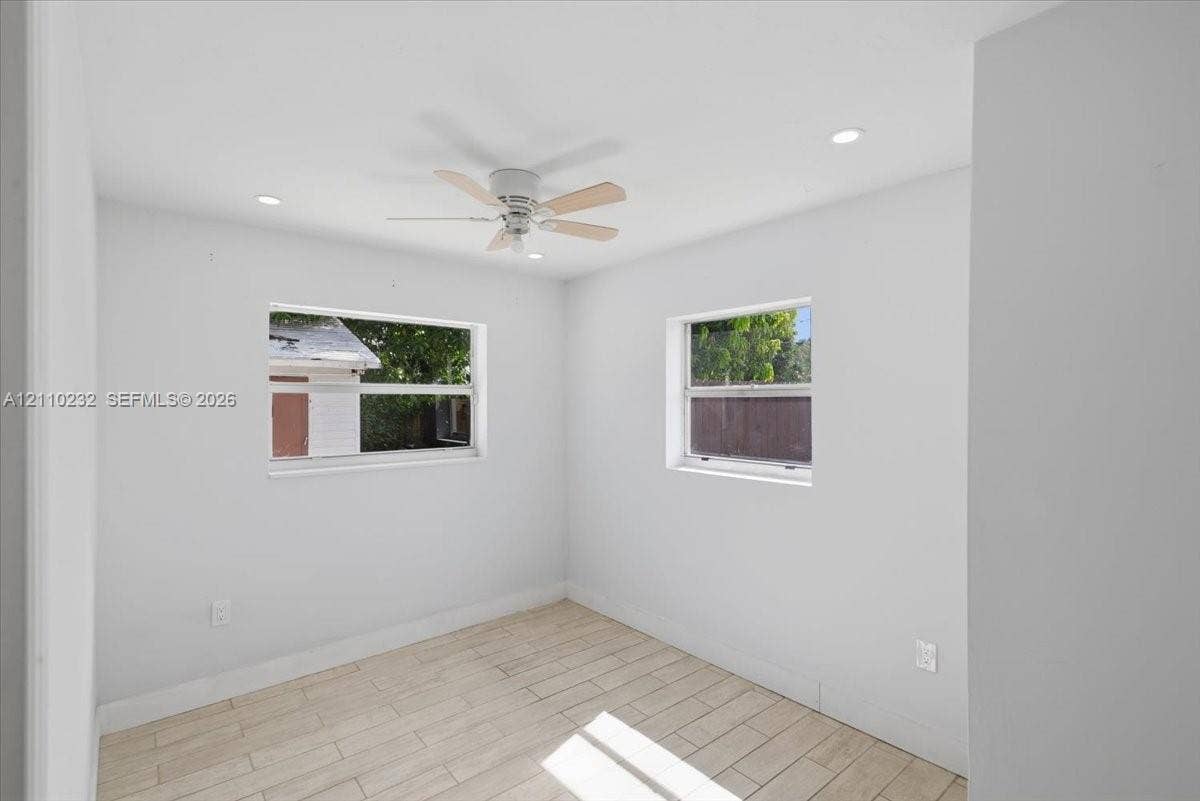Interior space featuring wood-finish tile flooring, recessed lighting, and a ceiling fan