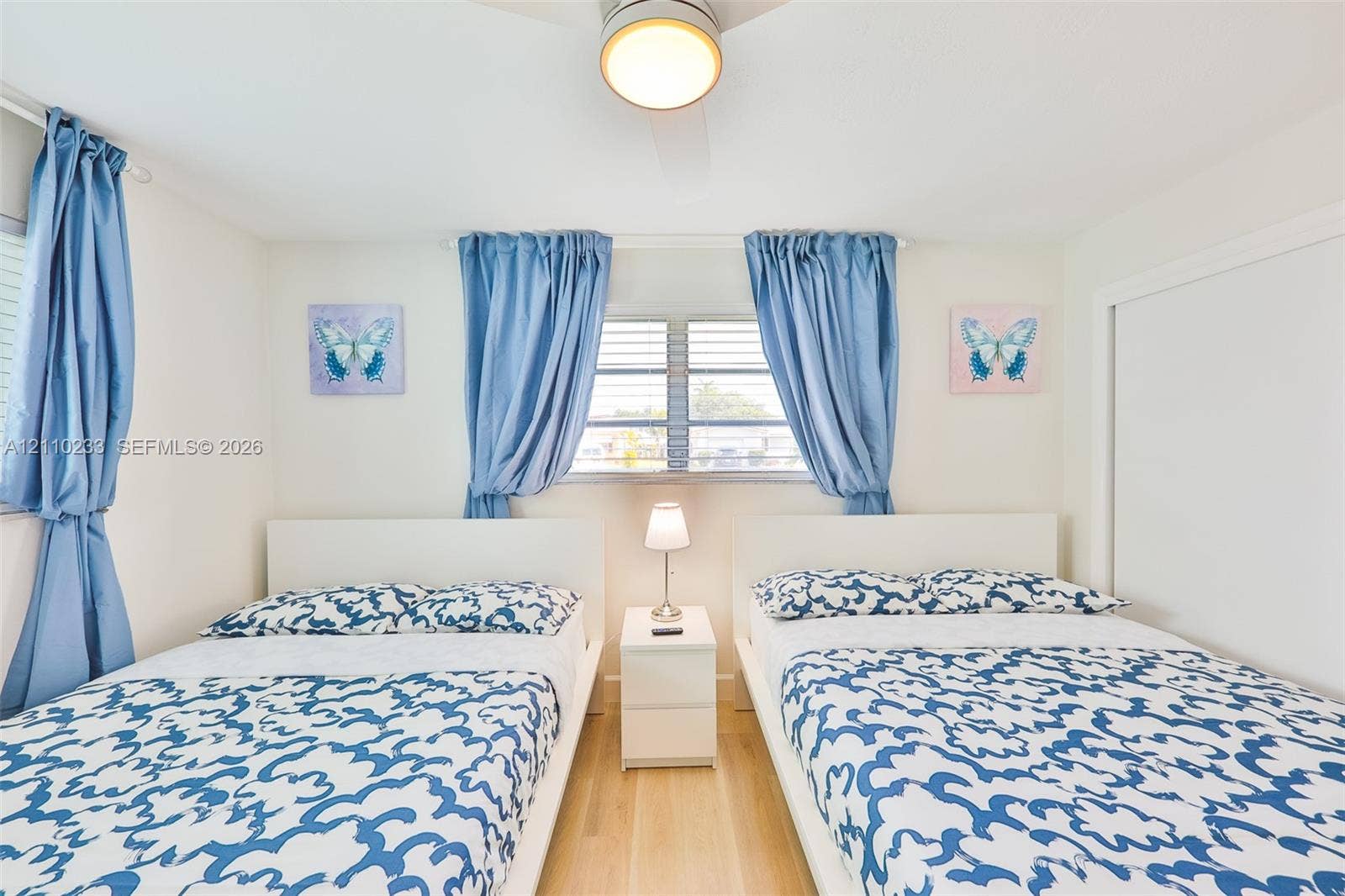 614 S Crescent Drive, Hollywood, FL 33021 Bedroom featuring wood-finish flooring, louvered windows, and a ceiling-mounted light fixture