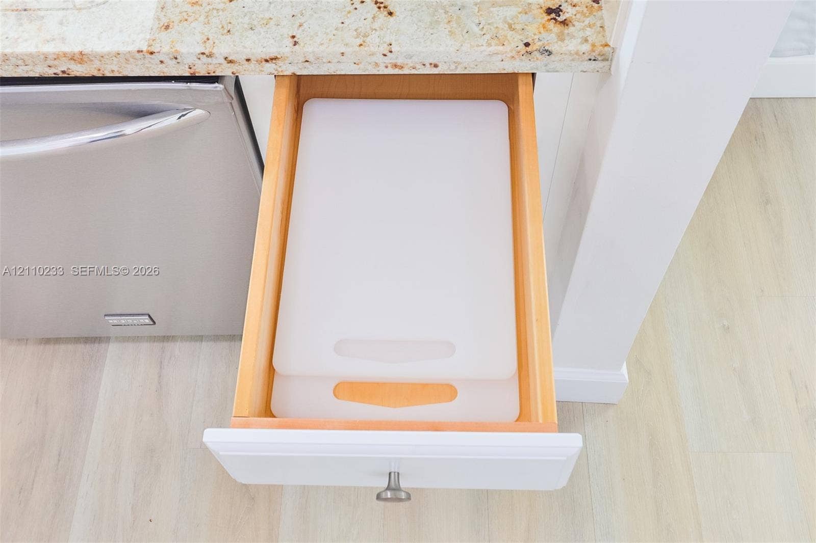 614 S Crescent Drive, Hollywood, FL 33021 Custom-fit drawer with natural wood finish, stone-surface countertop, stainless steel dishwasher, and satin-finish metal hardware