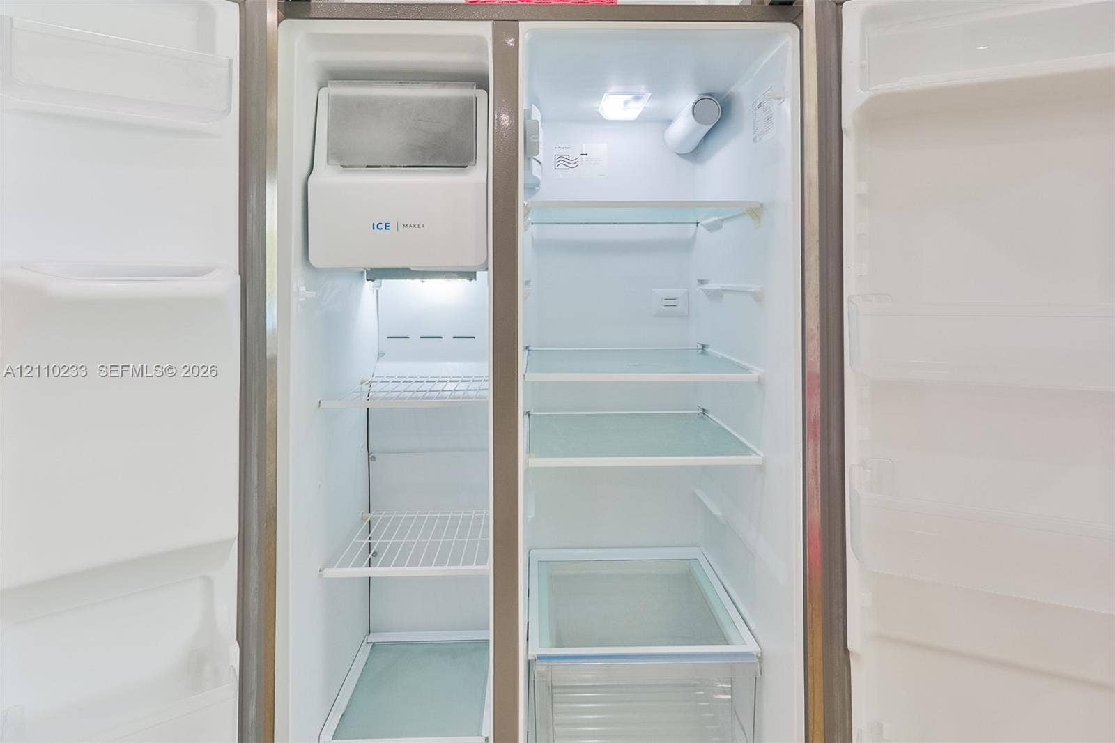 614 S Crescent Drive, Hollywood, FL 33021 Side-by-side refrigerator featuring adjustable glass shelving, an integrated ice and water dispenser, and a dedicated crisper drawer