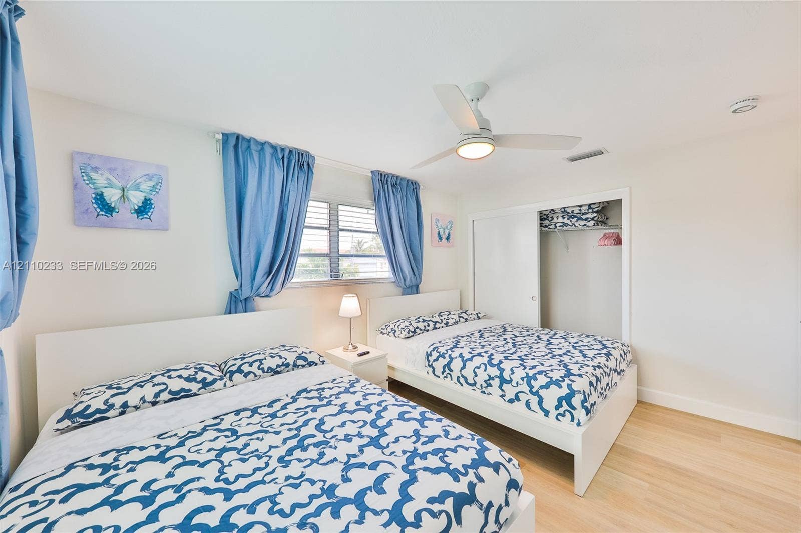 614 S Crescent Drive, Hollywood, FL 33021 Room featuring wood-finish flooring, a ceiling fan with integrated lighting, horizontal window blinds, and a built-in closet with sliding doors