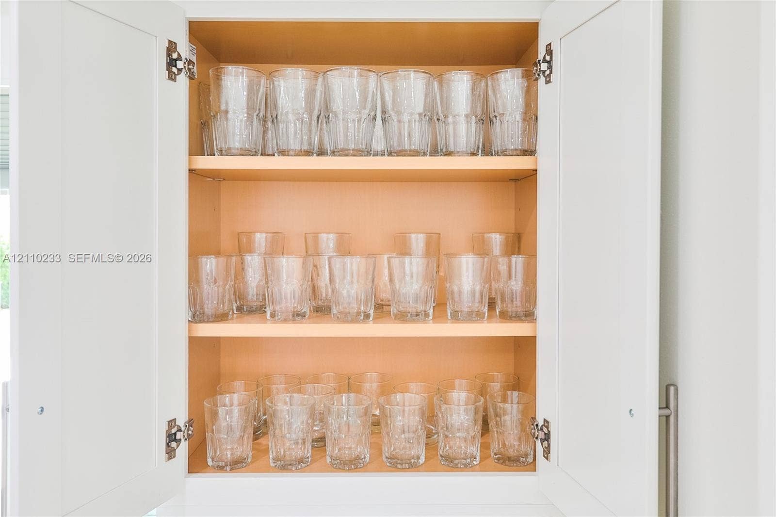 614 S Crescent Drive, Hollywood, FL 33021 Shaker-style cabinet doors with a matte finish, concealed hinges, and stainless steel bar pulls, featuring adjustable wood-toned shelving