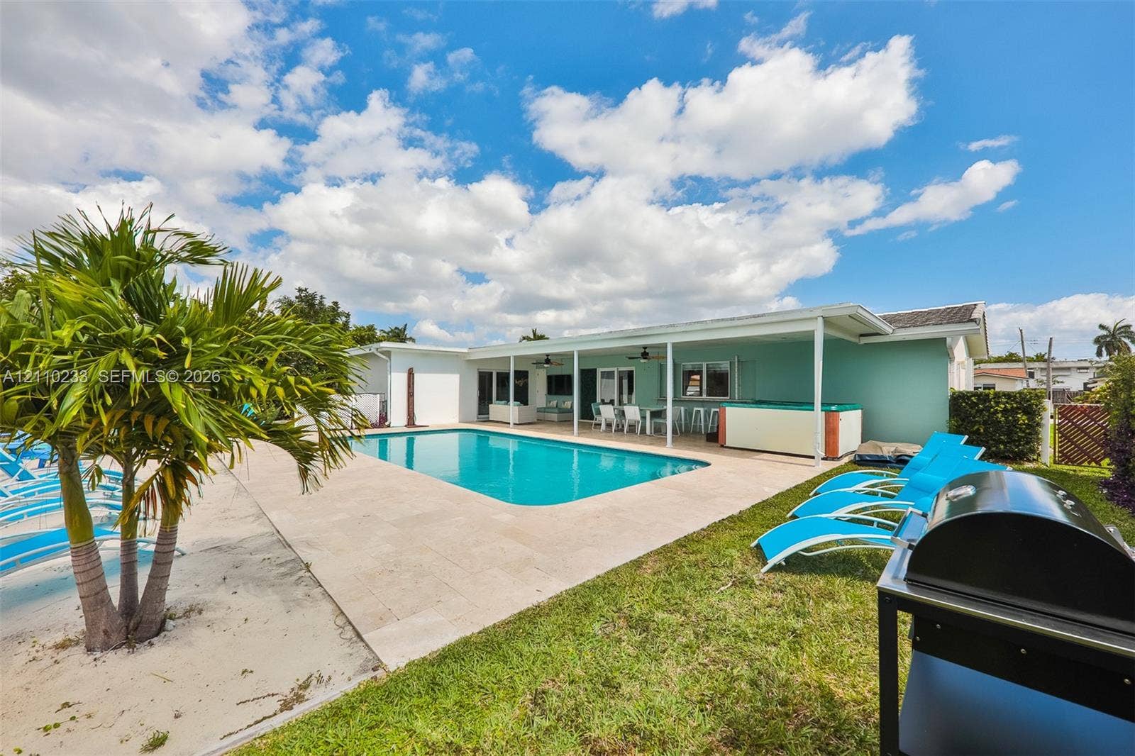 614 S Crescent Drive, Hollywood, FL 33021 In-ground swimming pool with stone paver decking, covered patio, and attached hot tub
