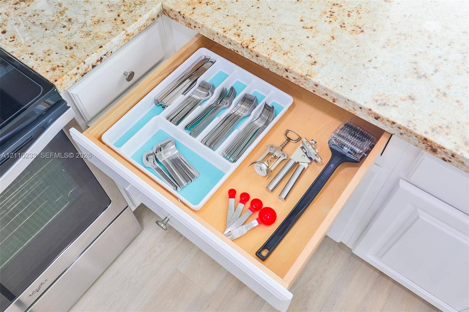 614 S Crescent Drive, Hollywood, FL 33021 Custom-fitted drawer cabinetry featuring natural wood finishes, paired with durable stone-finish countertops and white shaker-style cabinetry