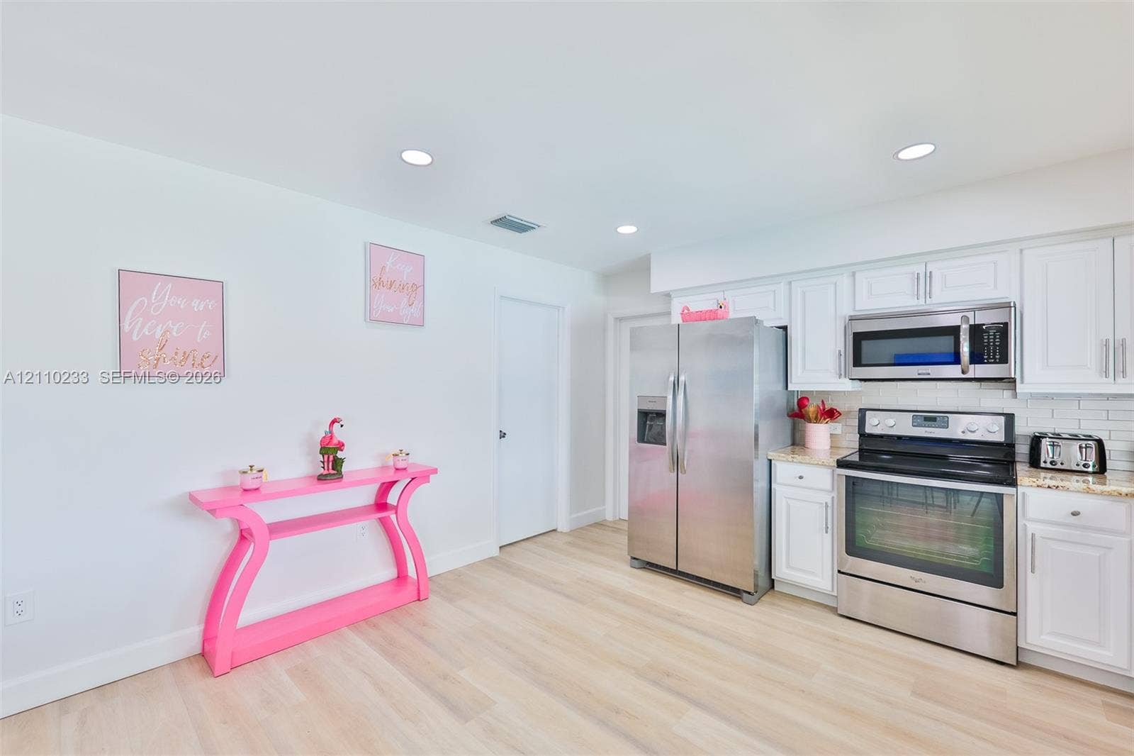 614 S Crescent Drive, Hollywood, FL 33021 Kitchen featuring white shaker-style cabinetry, stainless steel appliances, neutral stone-finish countertops, recessed lighting, and light-toned wood-finish flooring