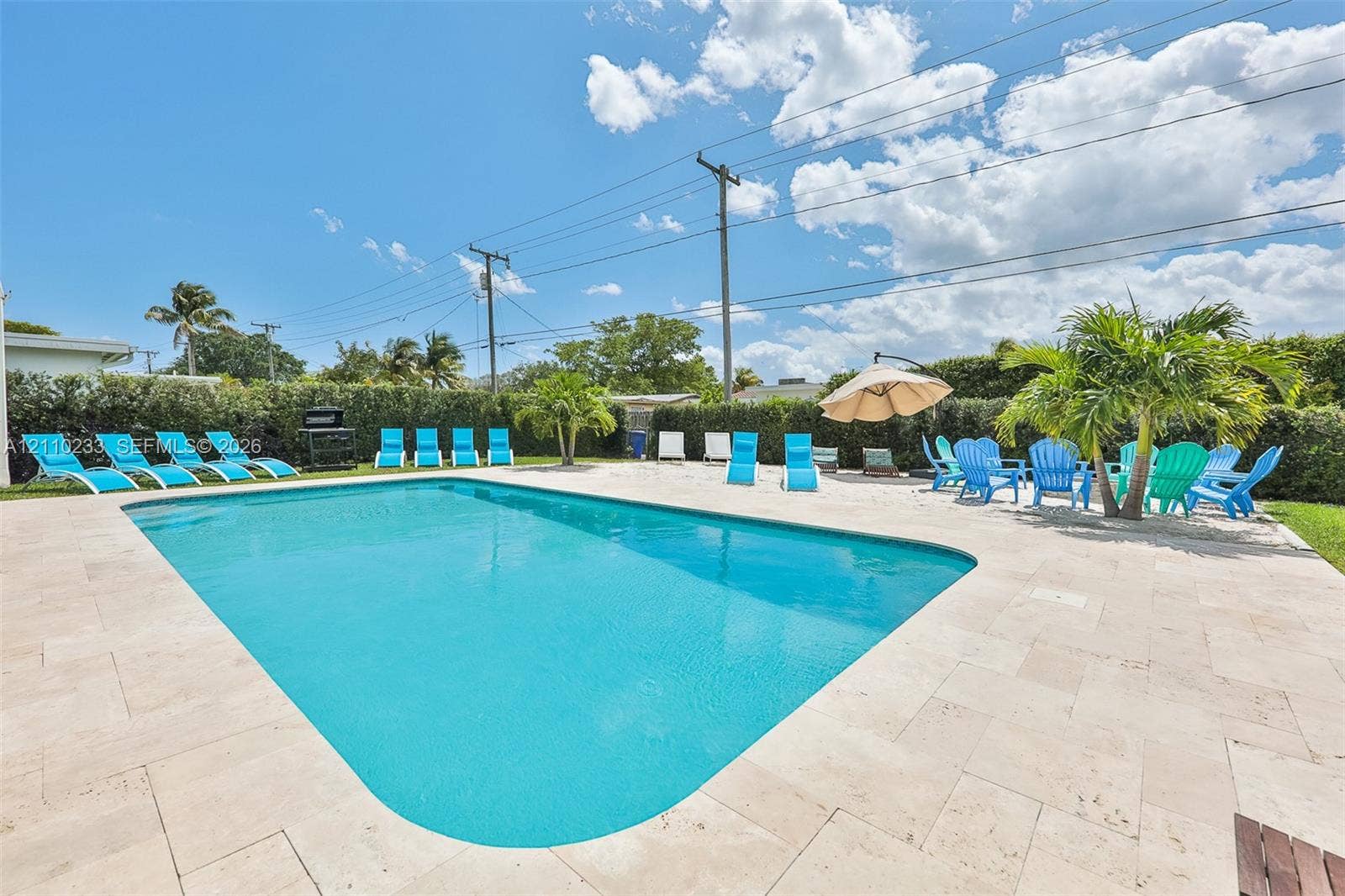 614 S Crescent Drive, Hollywood, FL 33021 In-ground swimming pool with stone-finish patio surround and perimeter greenery