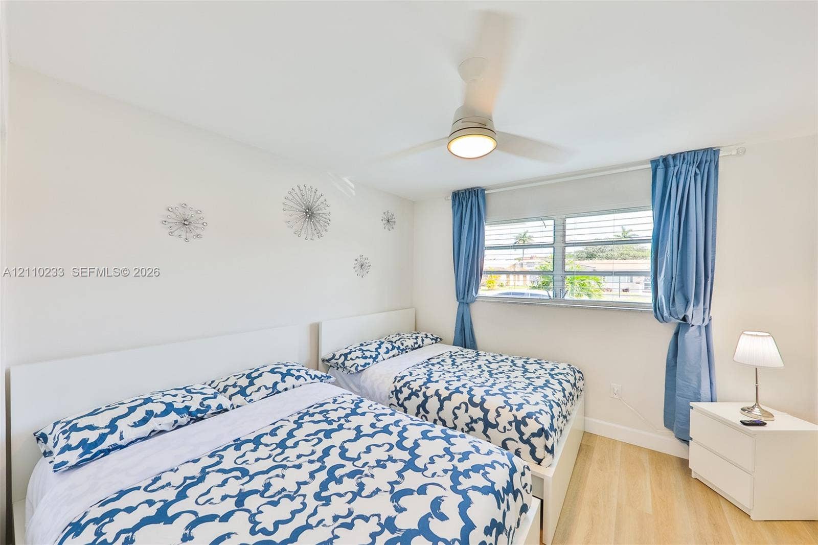 614 S Crescent Drive, Hollywood, FL 33021 Room featuring wood-finish flooring, a ceiling-mounted light fixture with fan, and louvered windows