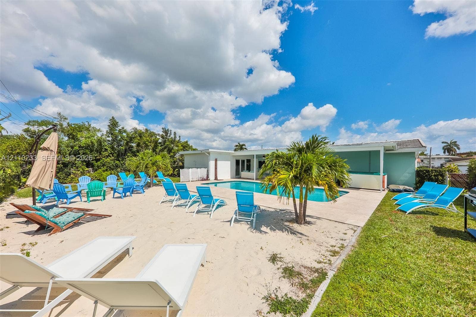 614 S Crescent Drive, Hollywood, FL 33021 In-ground swimming pool with concrete decking, sand-surfaced patio area, and manicured lawn