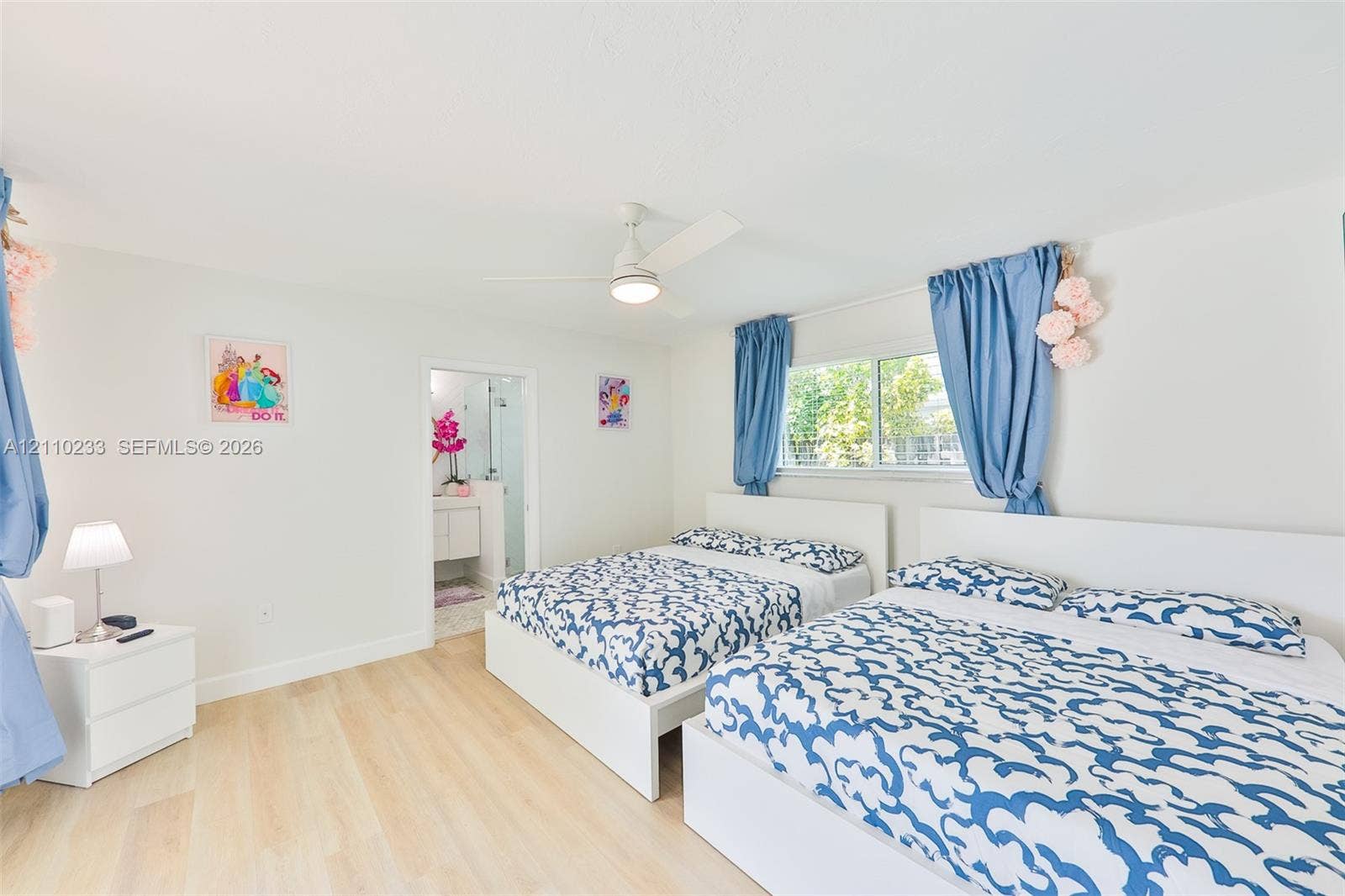 614 S Crescent Drive, Hollywood, FL 33021 Light-toned wood-finish flooring, ceiling-mounted fan with integrated lighting, and dual-pane horizontal sliding window