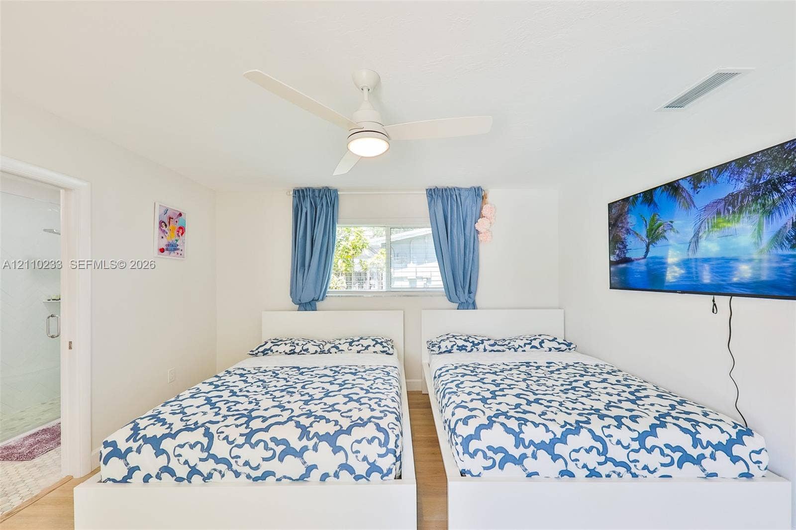 614 S Crescent Drive, Hollywood, FL 33021 Interior space featuring a white ceiling fan with integrated lighting and wood-finish flooring