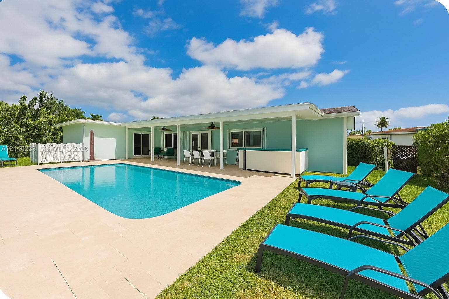 614 S Crescent Drive, Hollywood, FL 33021 In-ground swimming pool featuring a concrete pool deck, covered patio, and built-in exterior bar