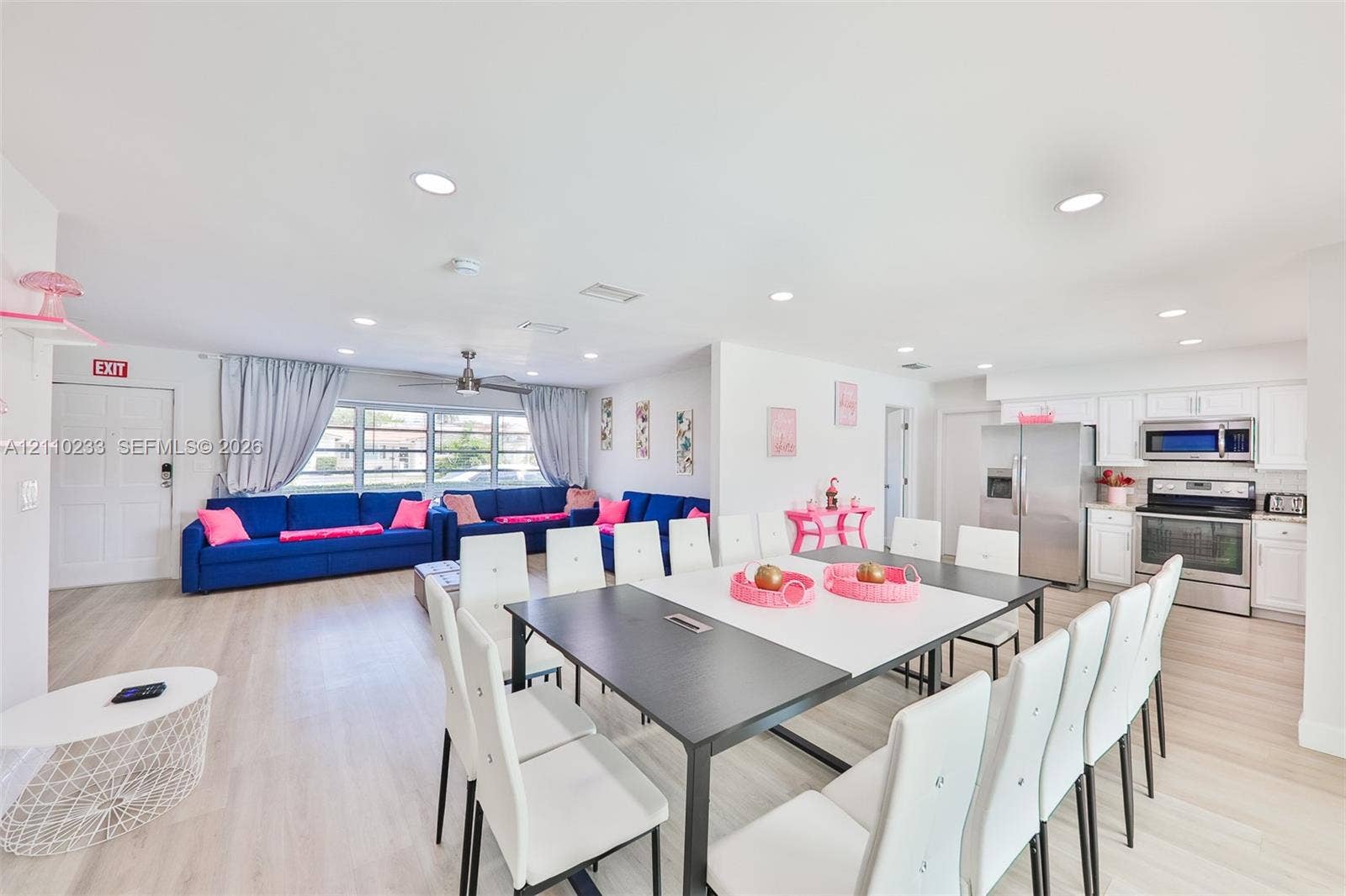 614 S Crescent Drive, Hollywood, FL 33021 Open-concept living space featuring wood-finish flooring, recessed lighting, white cabinetry, stainless steel appliances, and a central ceiling fan