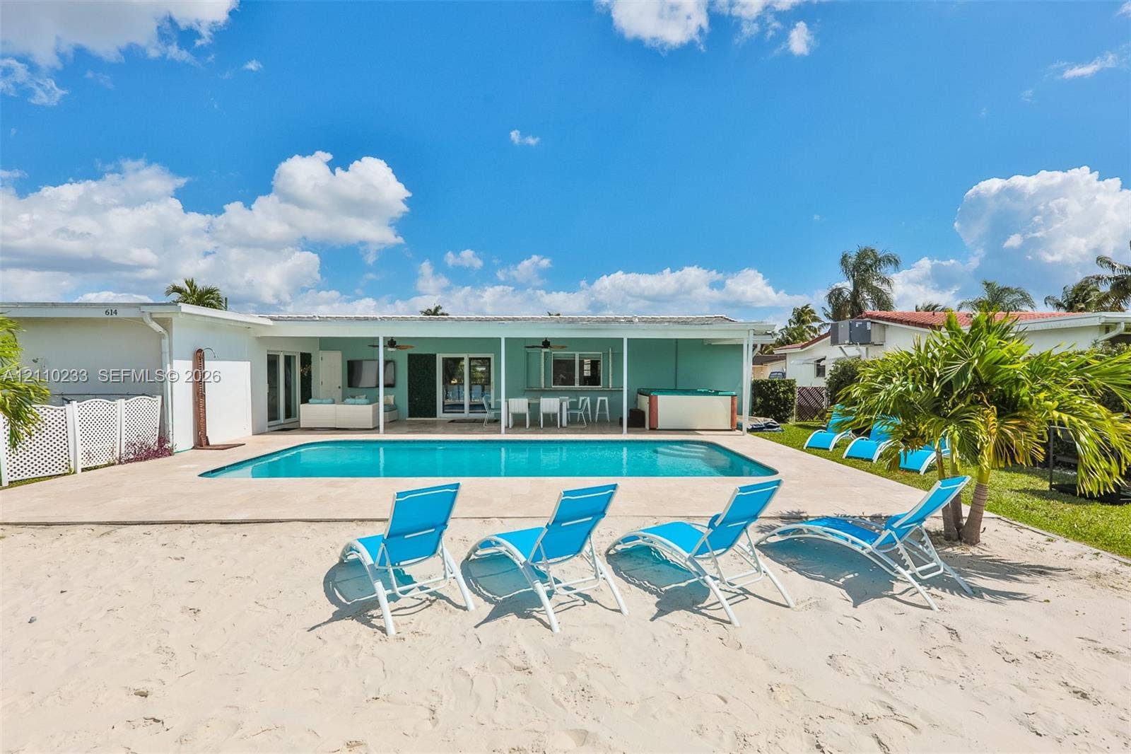 614 S Crescent Drive, Hollywood, FL 33021 In-ground swimming pool with an expansive concrete deck, covered patio space, and a private sandy beach area