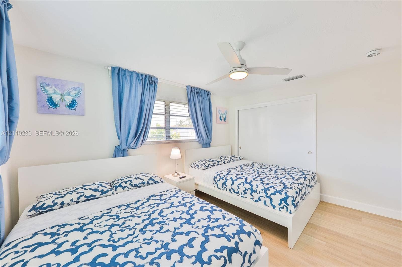614 S Crescent Drive, Hollywood, FL 33021 Wood-finish flooring, white sliding closet doors, and a ceiling-mounted fan with integrated lighting