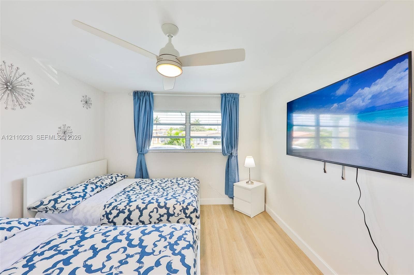 614 S Crescent Drive, Hollywood, FL 33021 Light-toned wood-finish flooring, ceiling fan with integrated lighting, and horizontal sliding windows