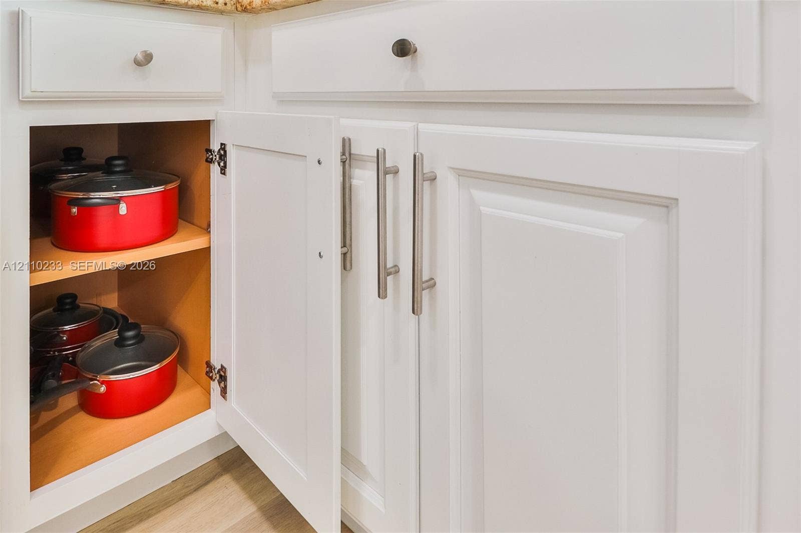 614 S Crescent Drive, Hollywood, FL 33021 White shaker-style cabinetry featuring satin nickel bar pulls, adjustable interior shelving, and soft-close hinges
