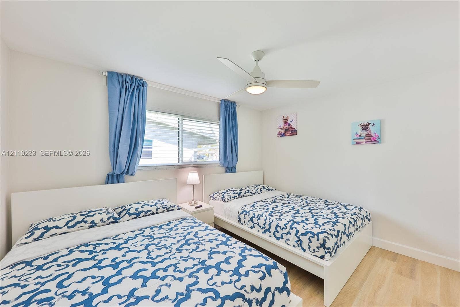 614 S Crescent Drive, Hollywood, FL 33021 Bright room featuring wood-finish flooring, a neutral color palette, and a central ceiling fan with an integrated light fixture